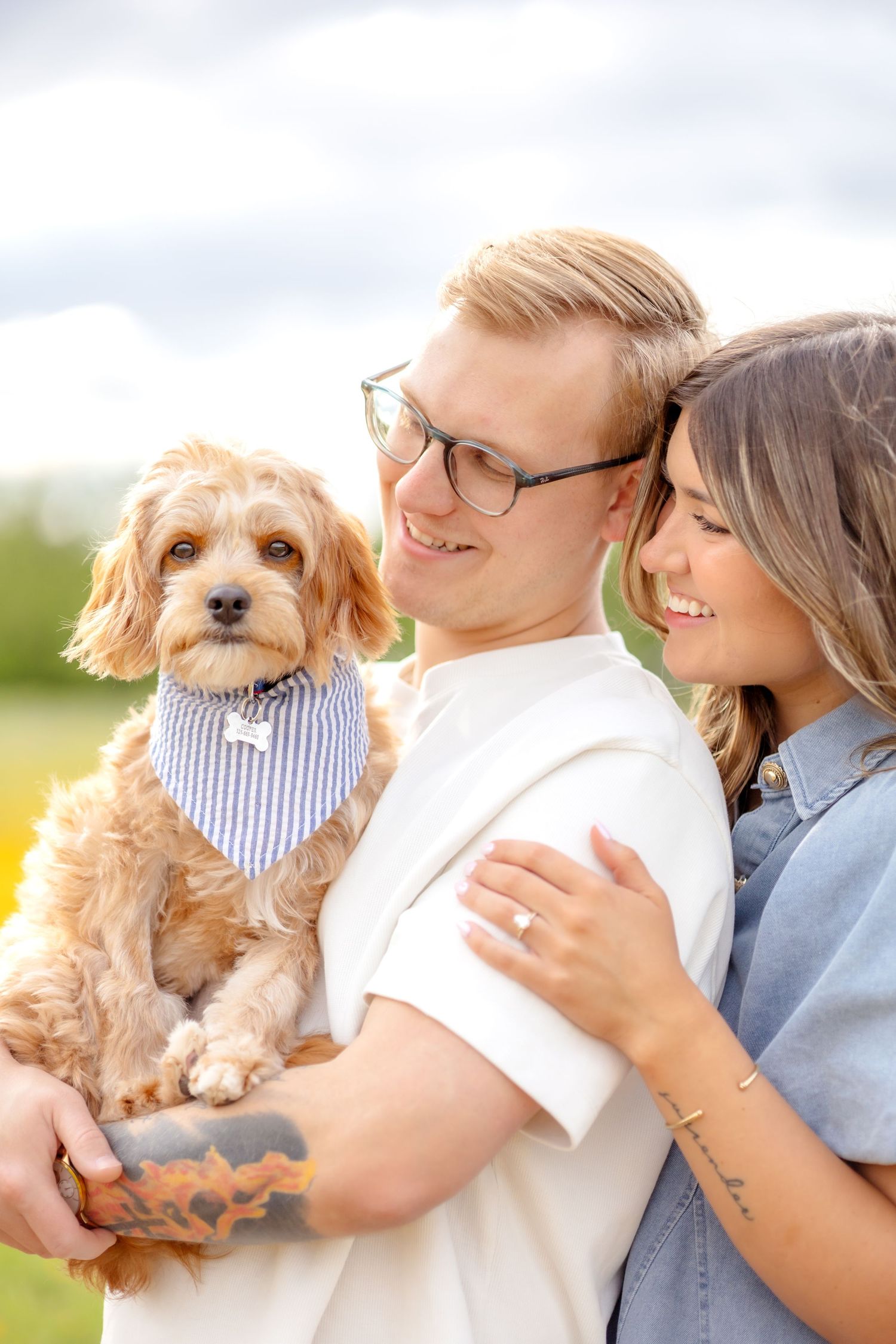 Married couple holding their puppy in a field in Abilene, Texas during a couple's photo session in Spring