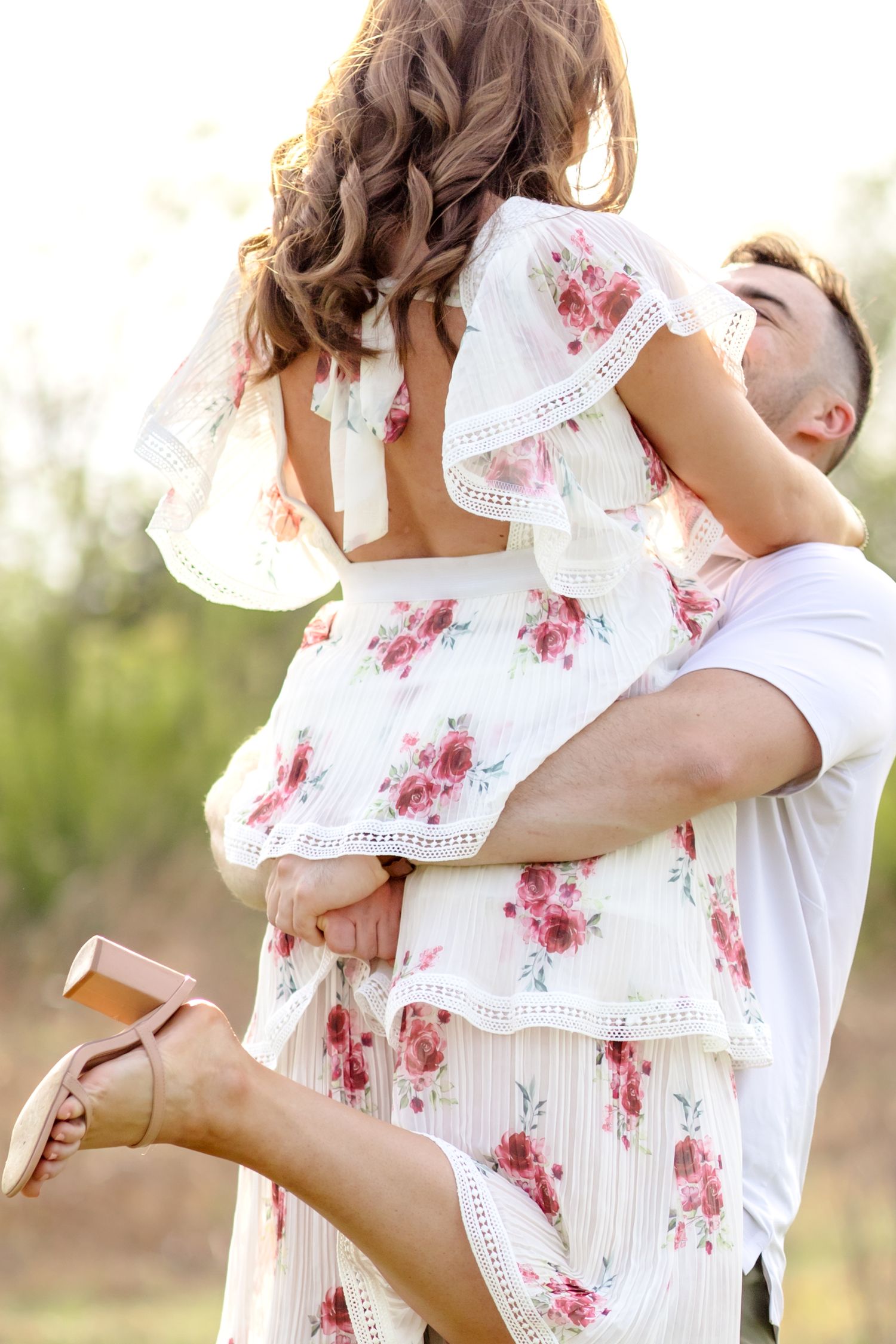 Couple doing a romantic lift and spinning around in a field in Dallas, Texas at White Rock Lake