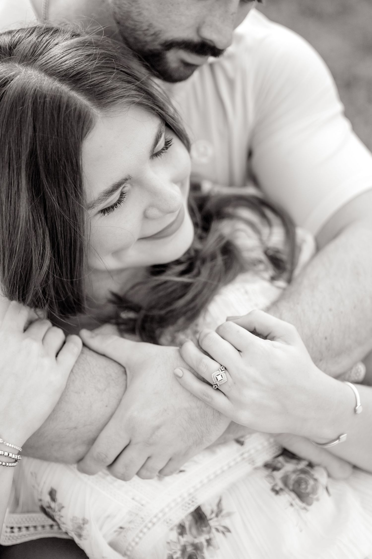 black and white image of couple cuddling together and closing their eyes in Dallas, TX