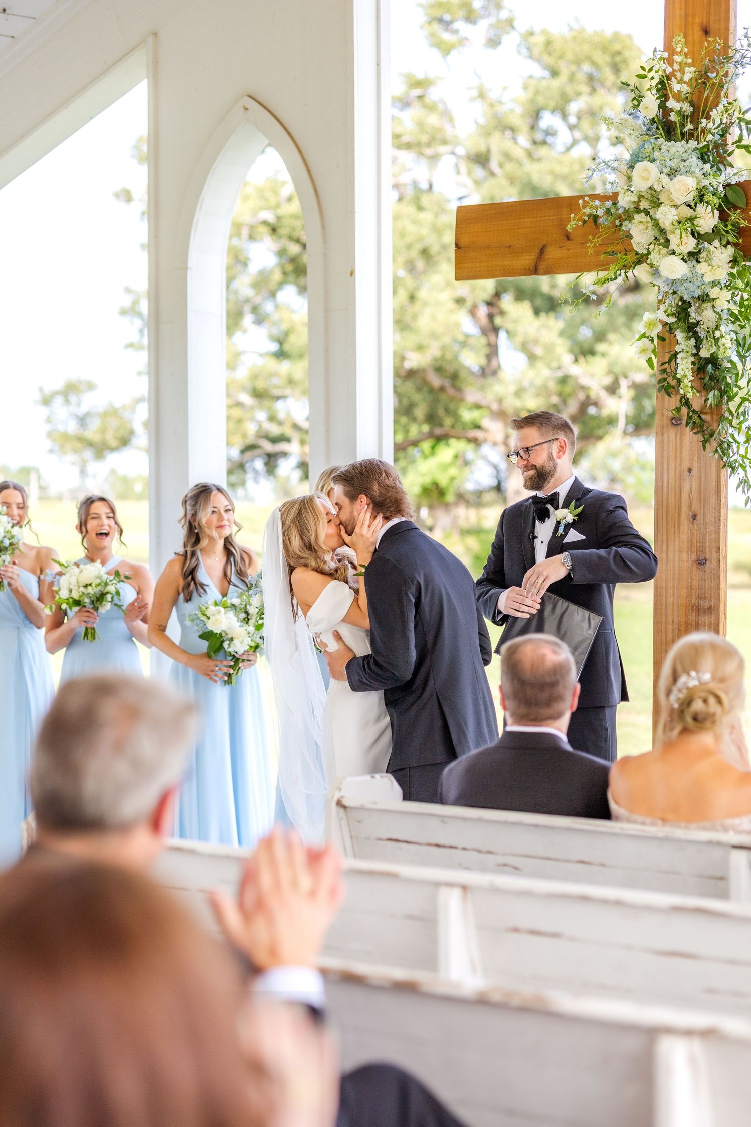 Bride and groom sharing their first kiss at their Dallas wedding ceremony at the open air chapel at Chandelier Farms