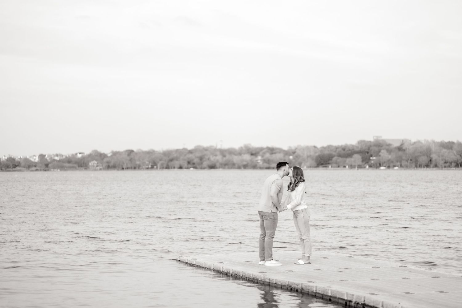 Married couple sharing a romantic kiss on the dock at White Rock Lake during couples photo session