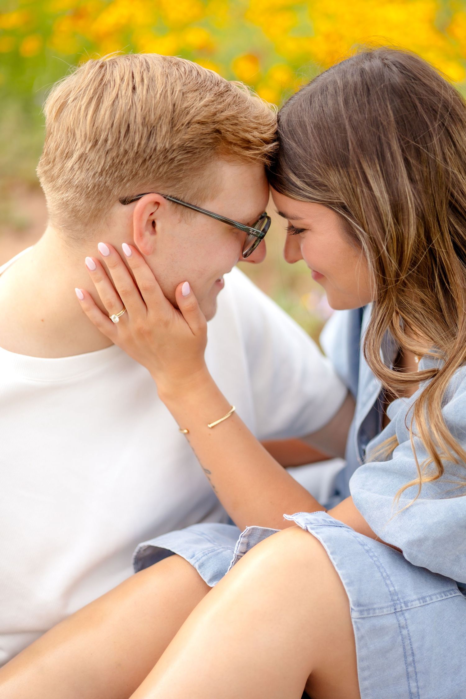 married couple nuzzled in close with their foreheads resting together and the wife resting her hand on her husband's cheek