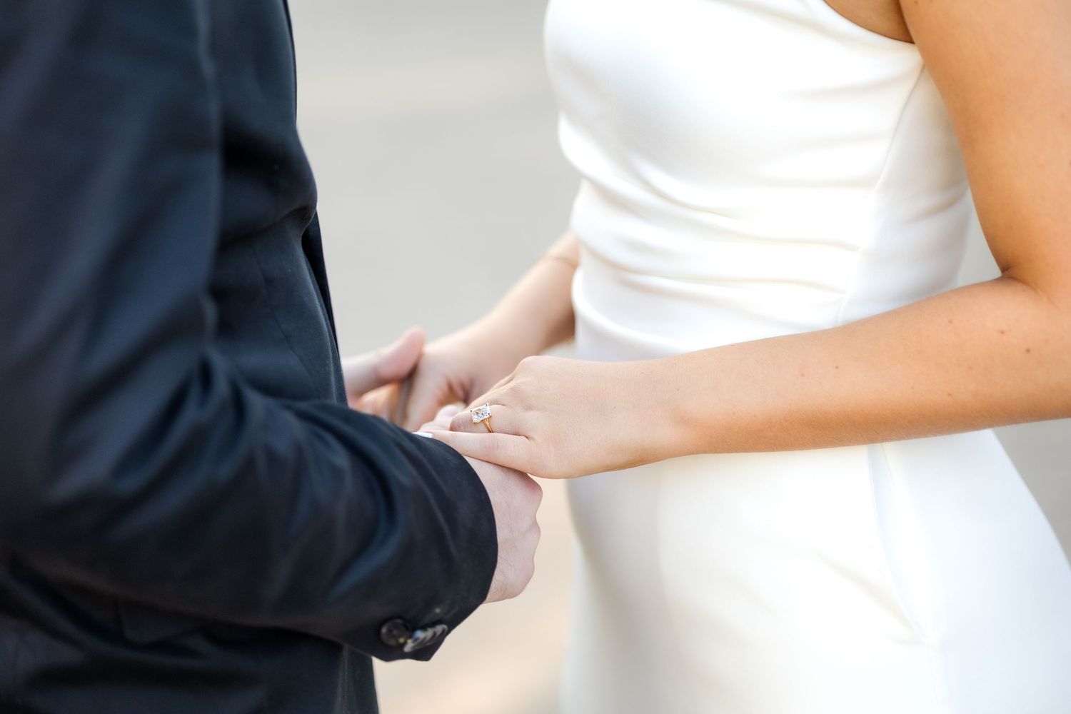 Engaged couple holding hands while sharing what they love about one another with a clear view of engagement ring