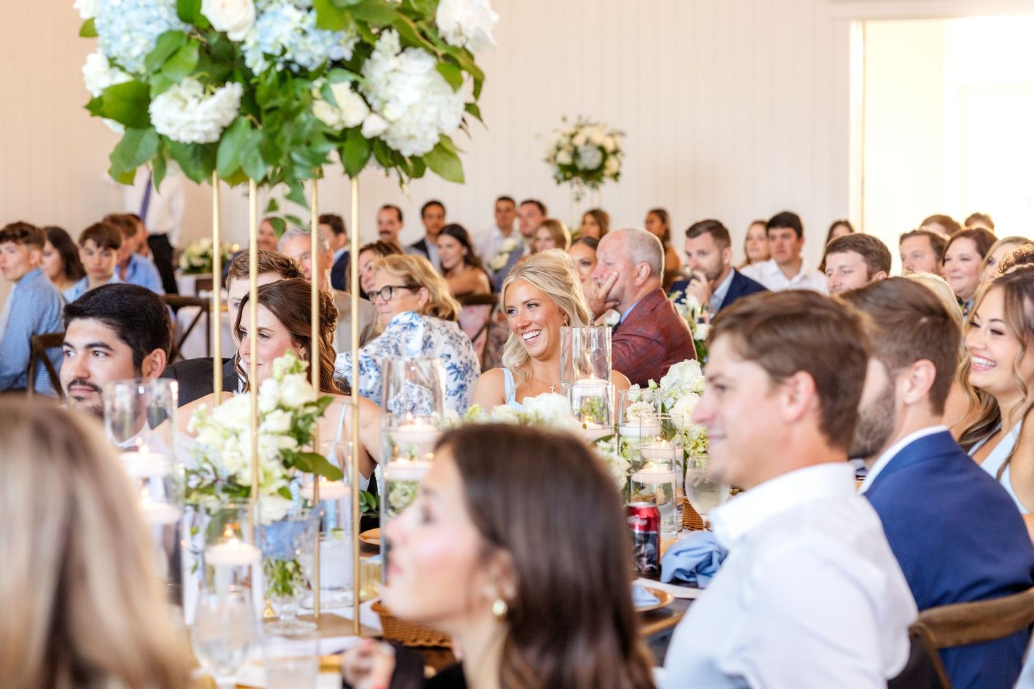 Guests smiling as wedding reception toasts are given