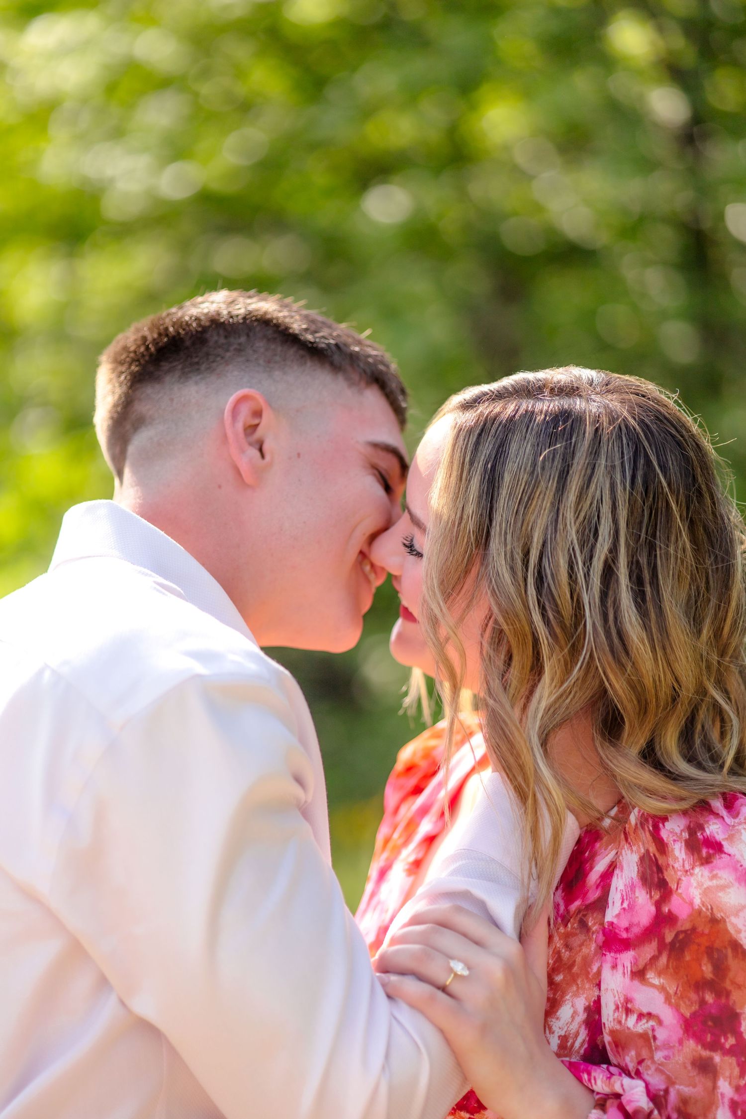 Engaged couple going in for a kiss at engagement photo session in Dallas, Texas.