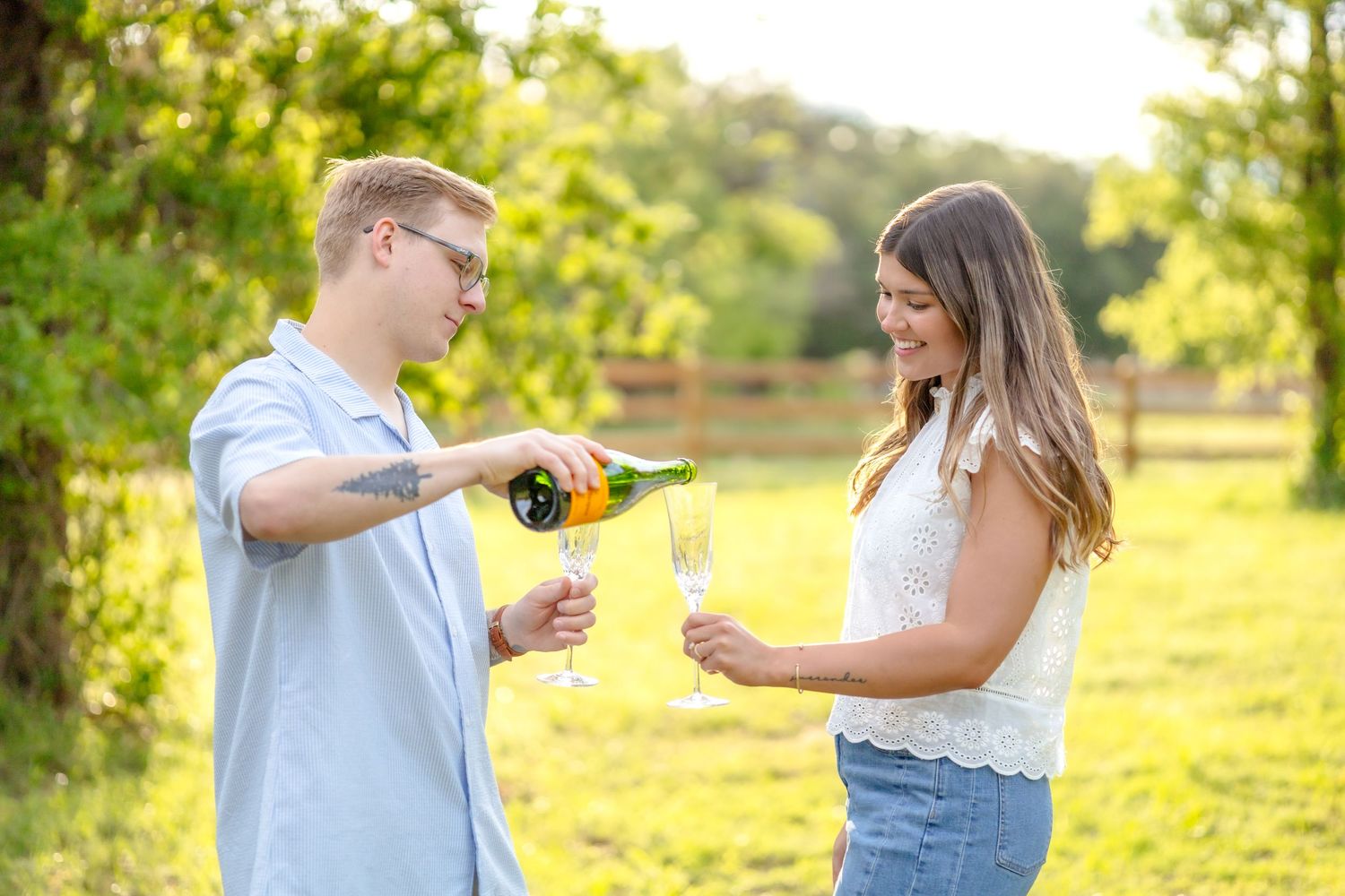 Husband pouring a glass of champagne for his wife during couple's photo session in Abilene, TX