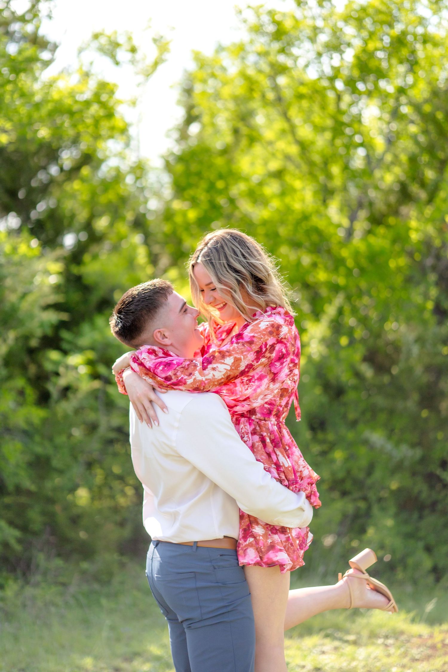 Engaged couple doing a romantic lift and spinning around