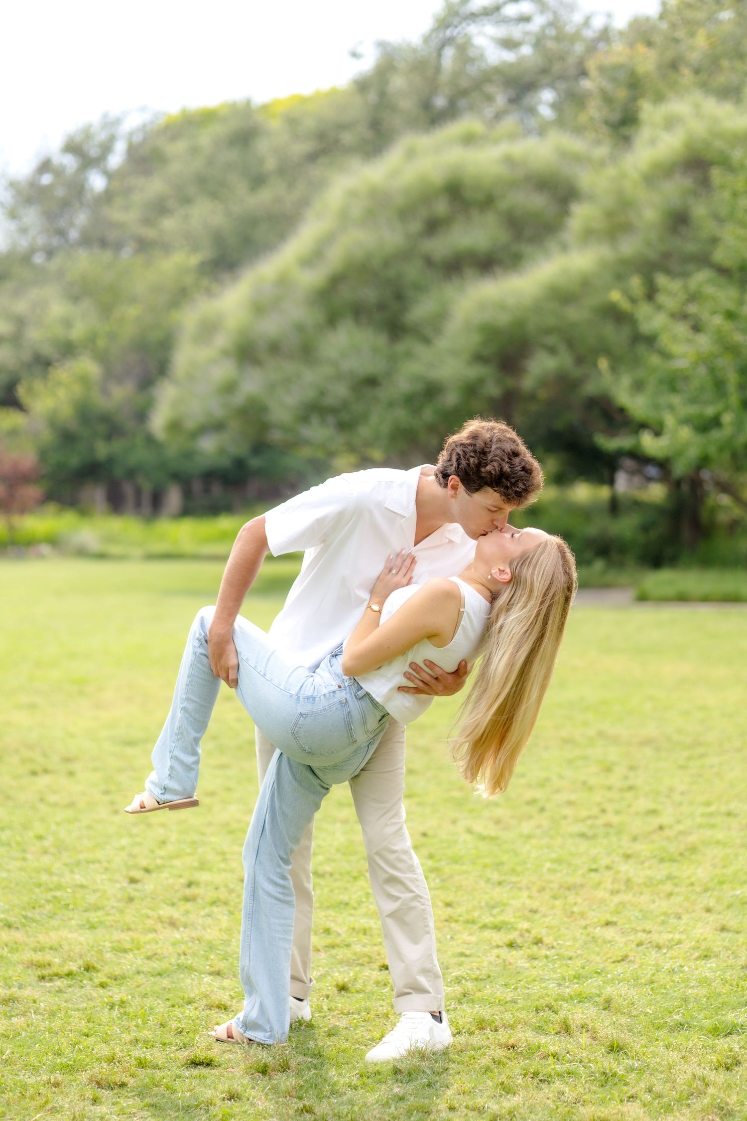 Engaged couple shared a romantic dip kiss in the field at Flippen Park in Dallas, Texas during engagement session