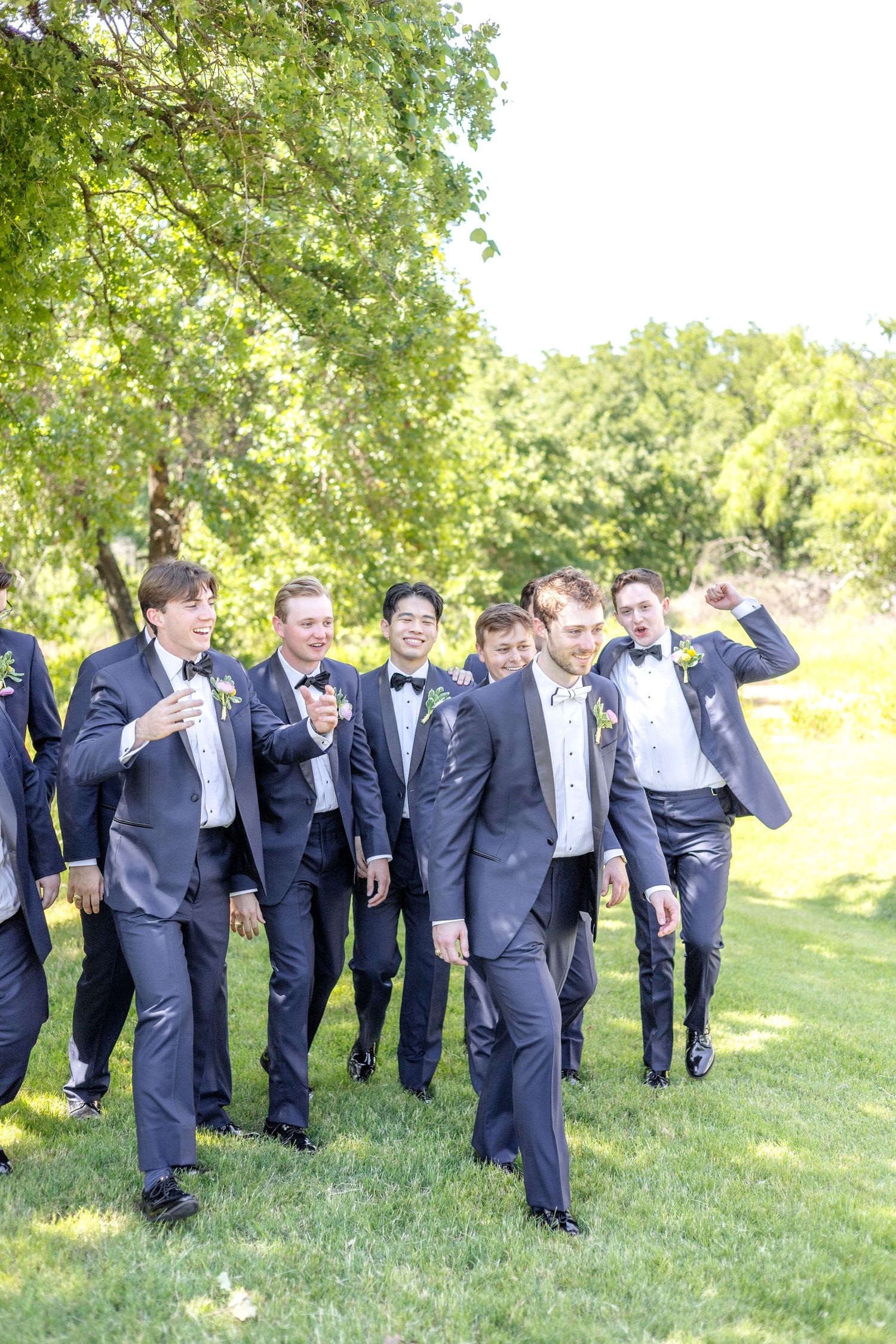 Groom and his groomsmen walking as they hype up the groom before the ceremony on his wedding day in Dallas, Texas