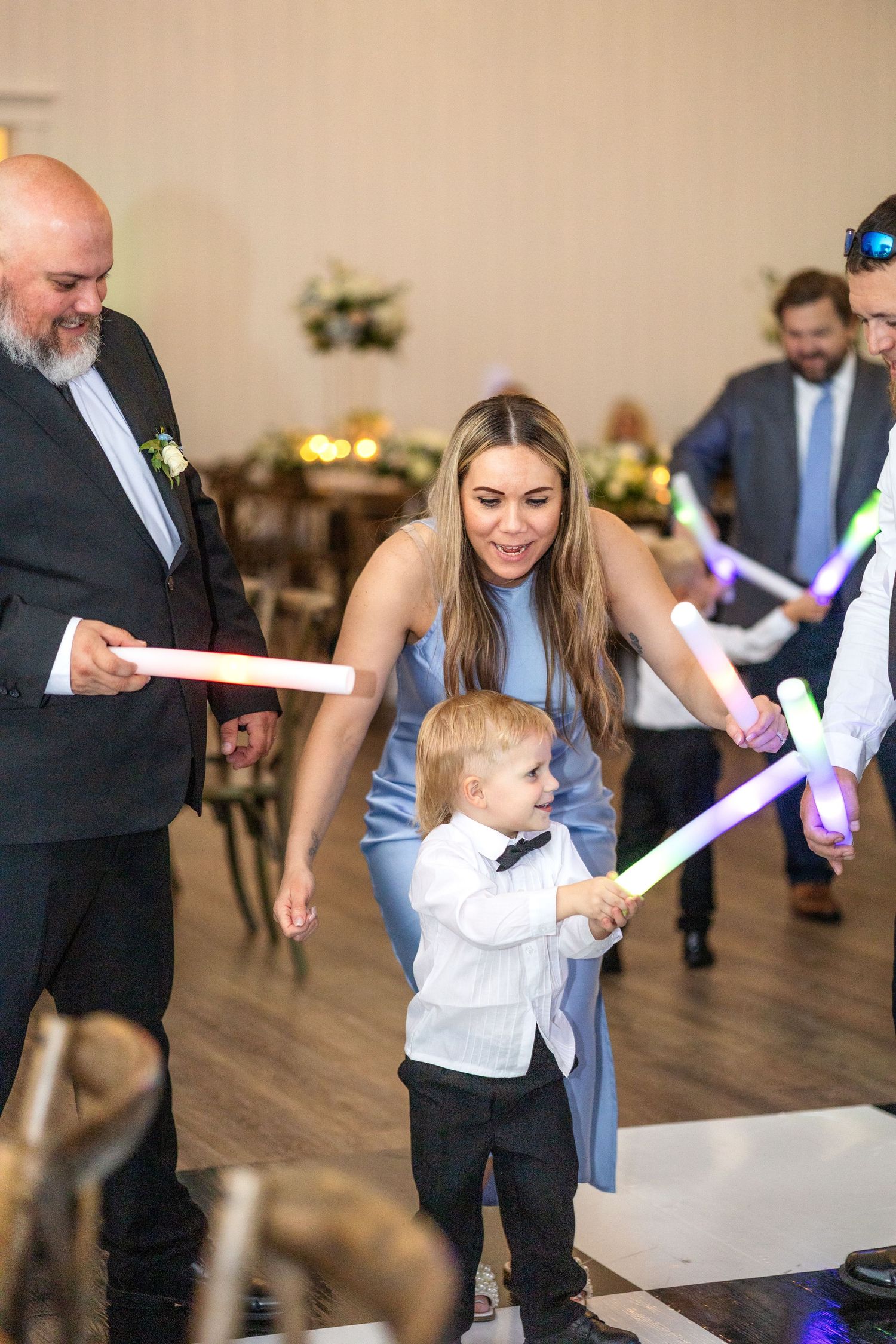 Little boy at wedding reception in Dallas waving around a glow stick while dancing