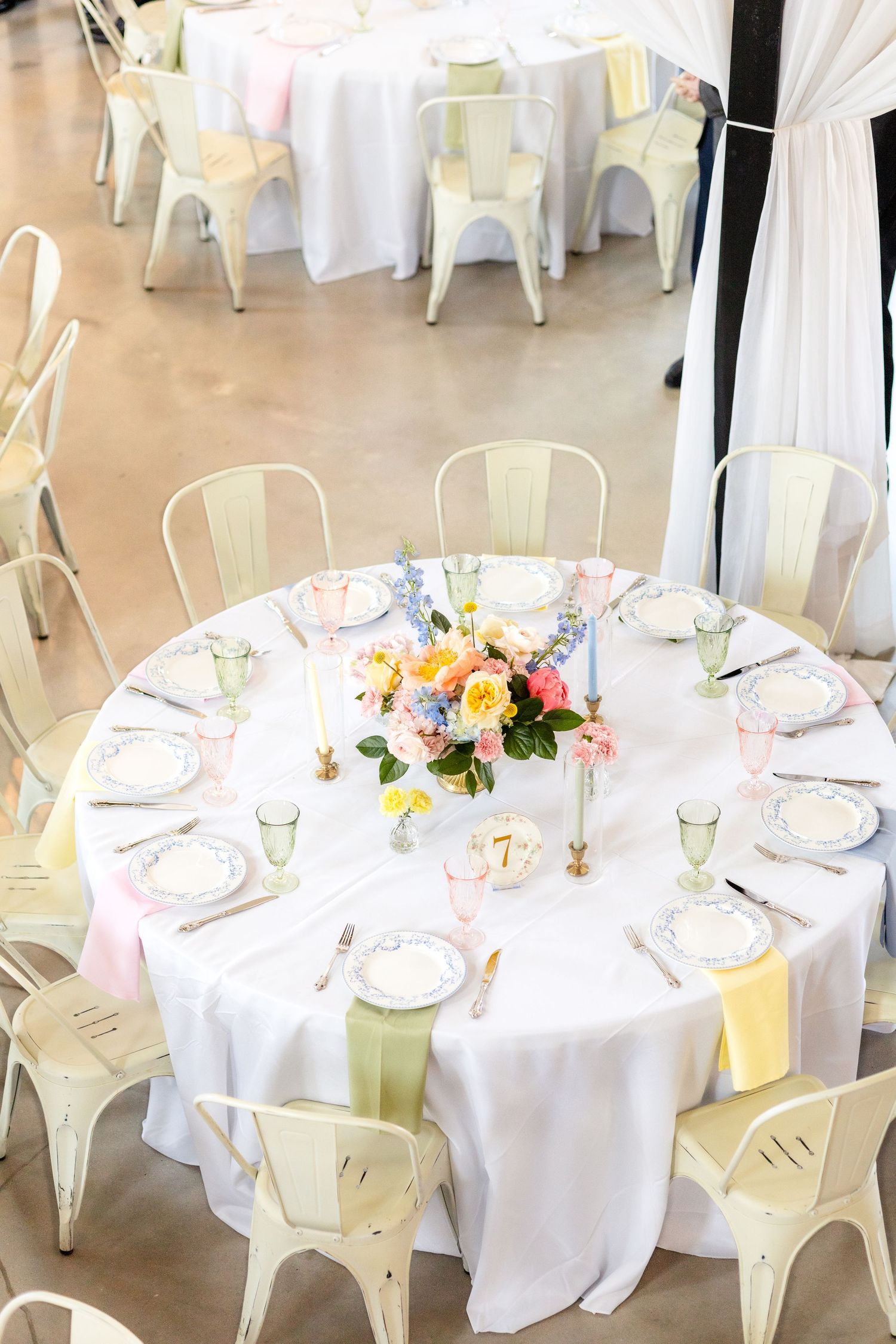 Aerial view of a wedding reception table with beautiful and colorful spring florals and candles at The Barn at Paradise Place Dallas wedding