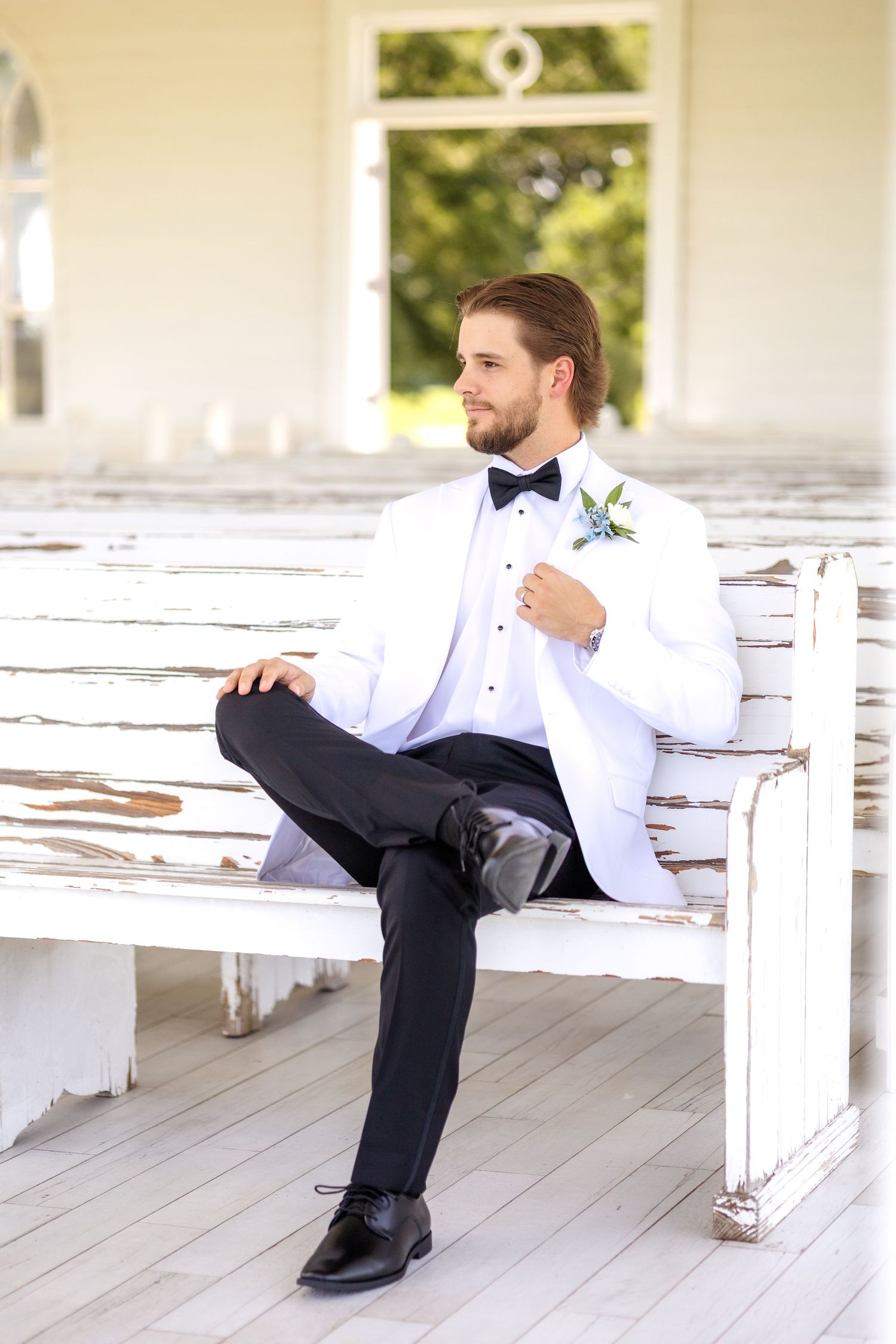 Groom sitting on wedding chapel pew in Dallas Texas