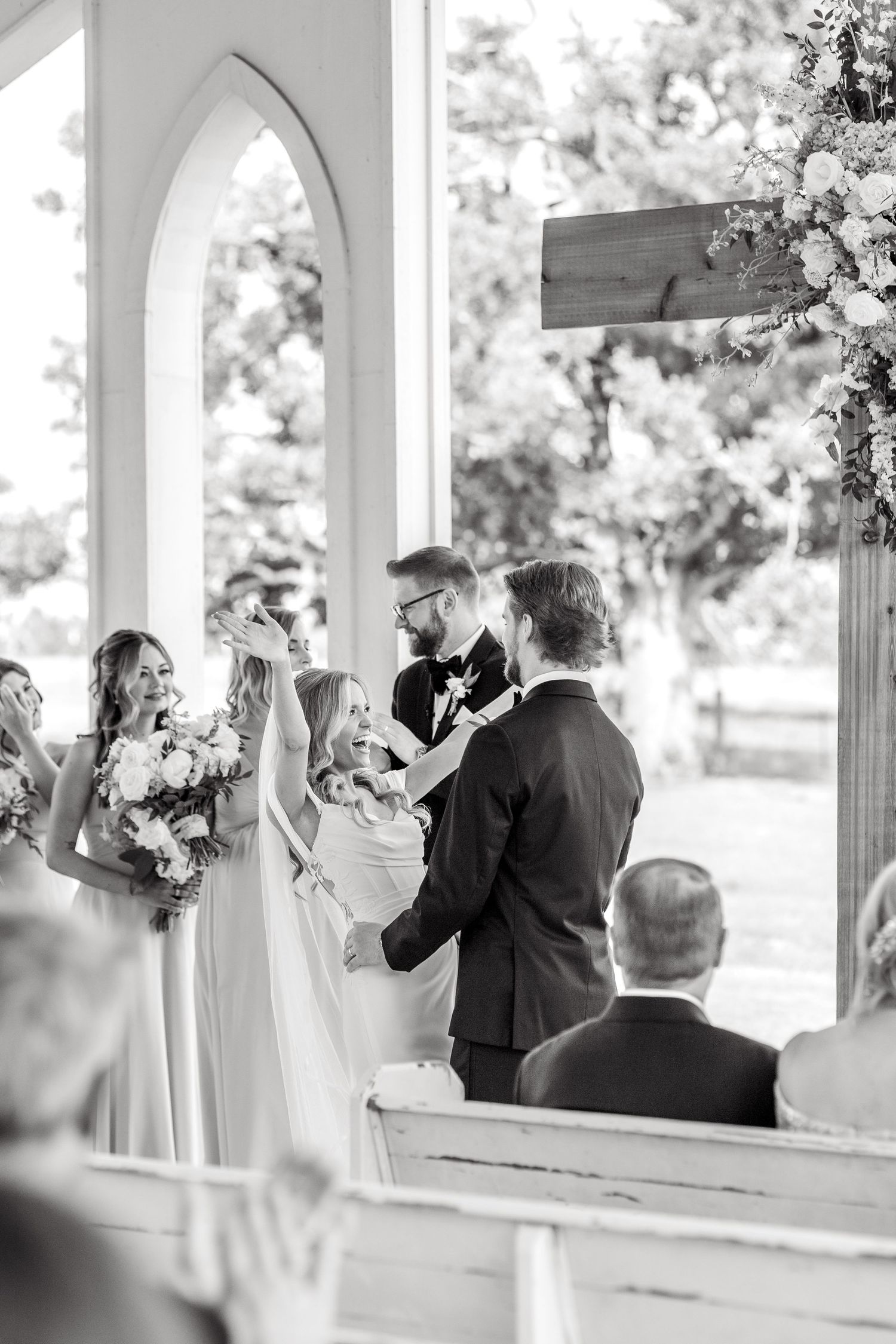 Bride throwing her hands in their air in celebration and excitement just after the first kiss at her wedding ceremony in Dallas, Texas