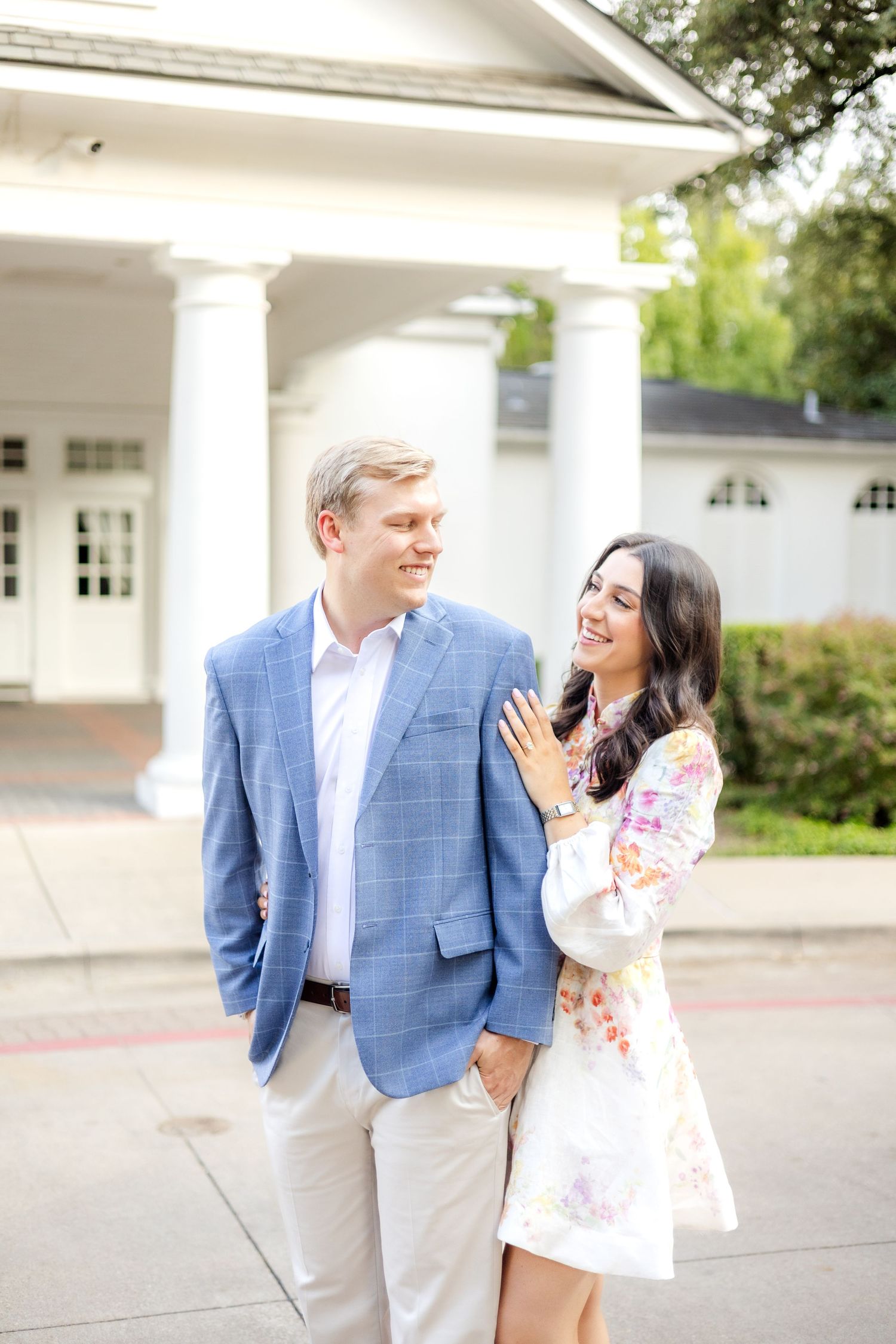 Woman standing behind her fiancé and smiling at one another
