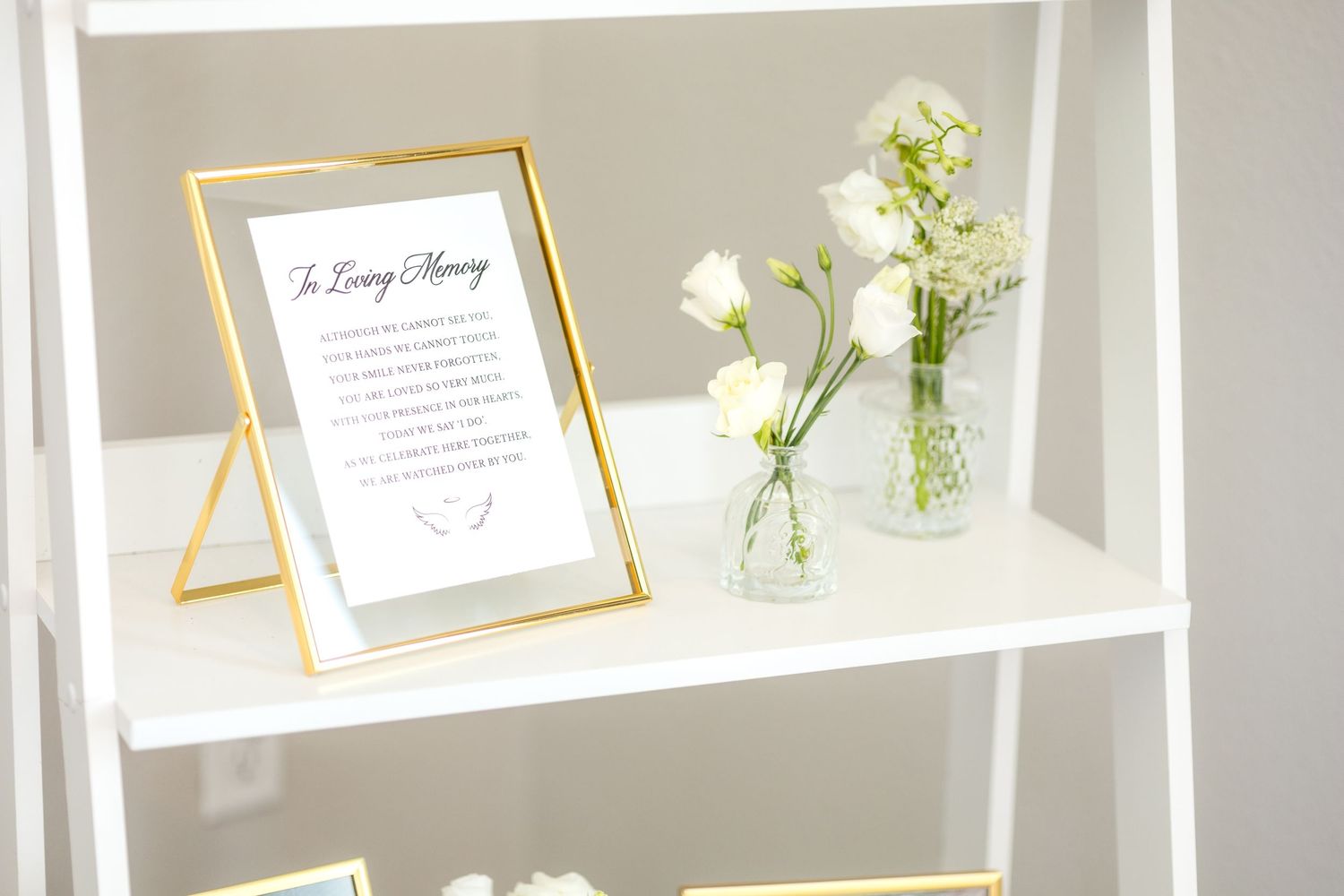 Sign sitting on a shelf next to white bud vases that says 