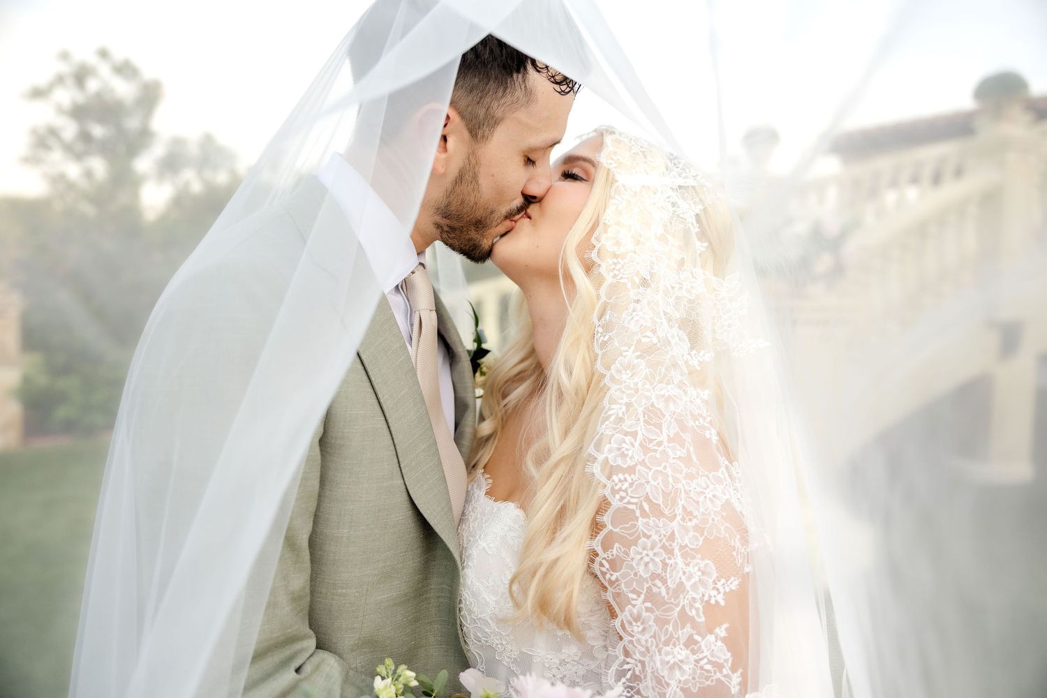 Bride and groom kissing under the veil at Dallas wedding