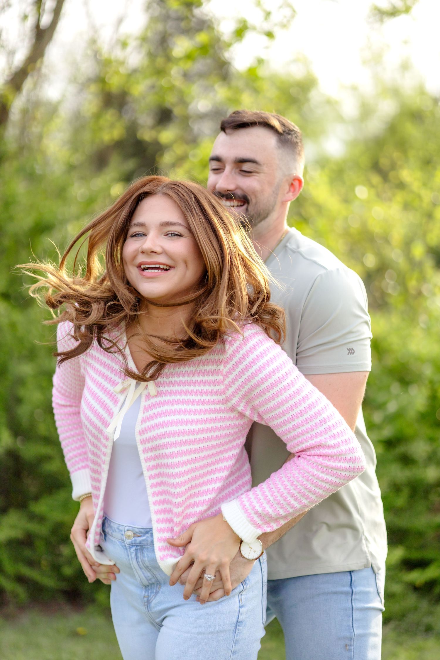 Married couple playing around in a field at White Rock Lake