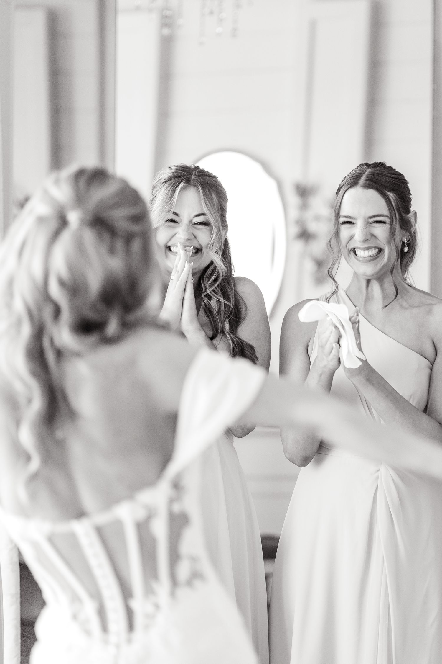 Bridesmaids smiling as they see the bride in her dress for the first time at Dallas wedding venue