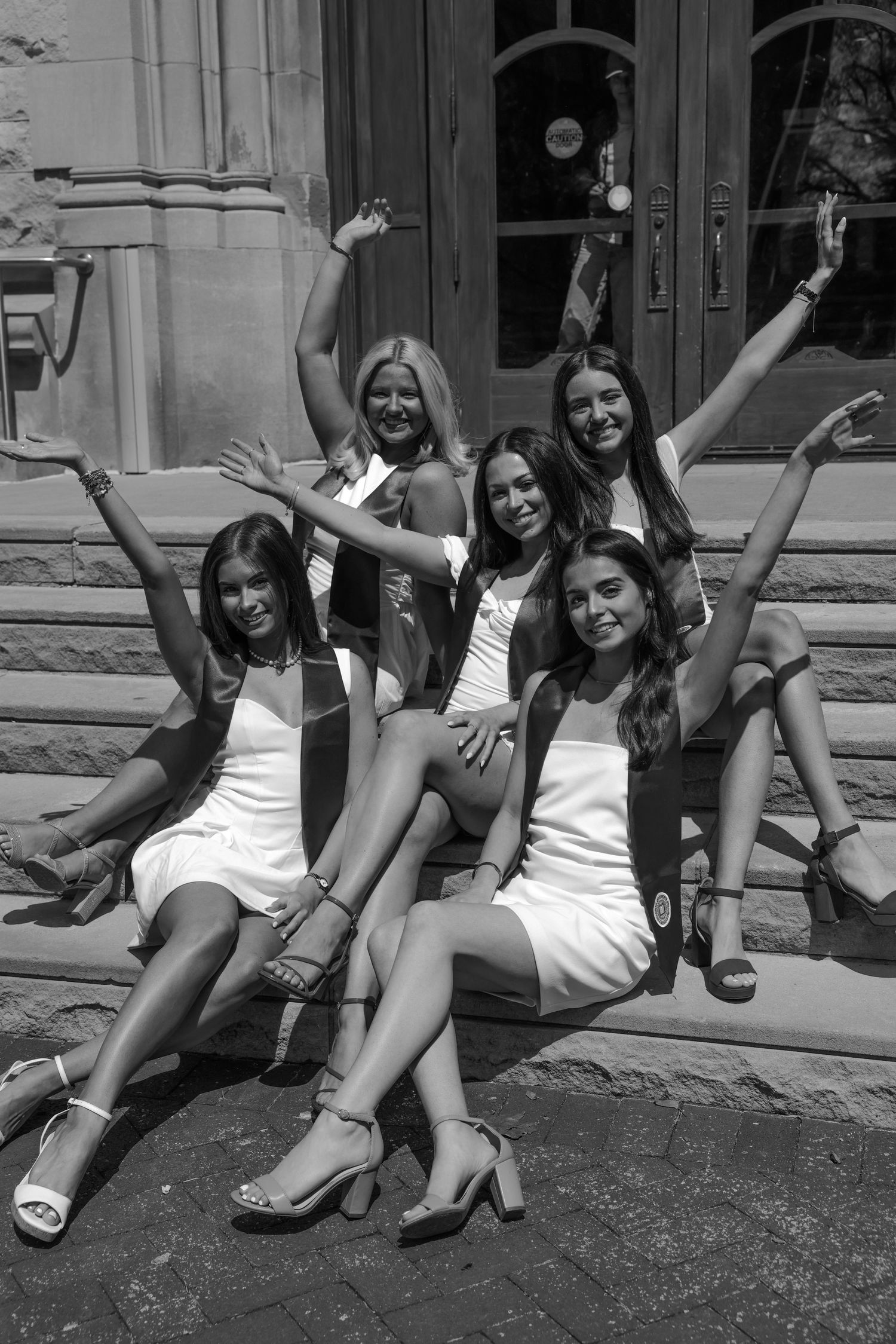 Picture of girls sitting on stairs in front of the building she went to school in at IU campus