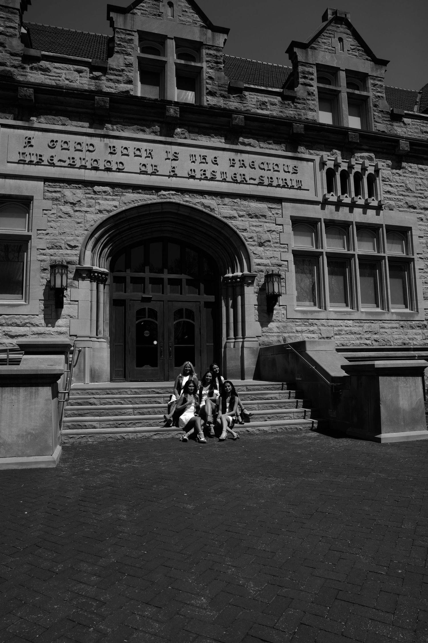 Picture of a girl sitting on stairs in front of the building she went to school in at IU campus