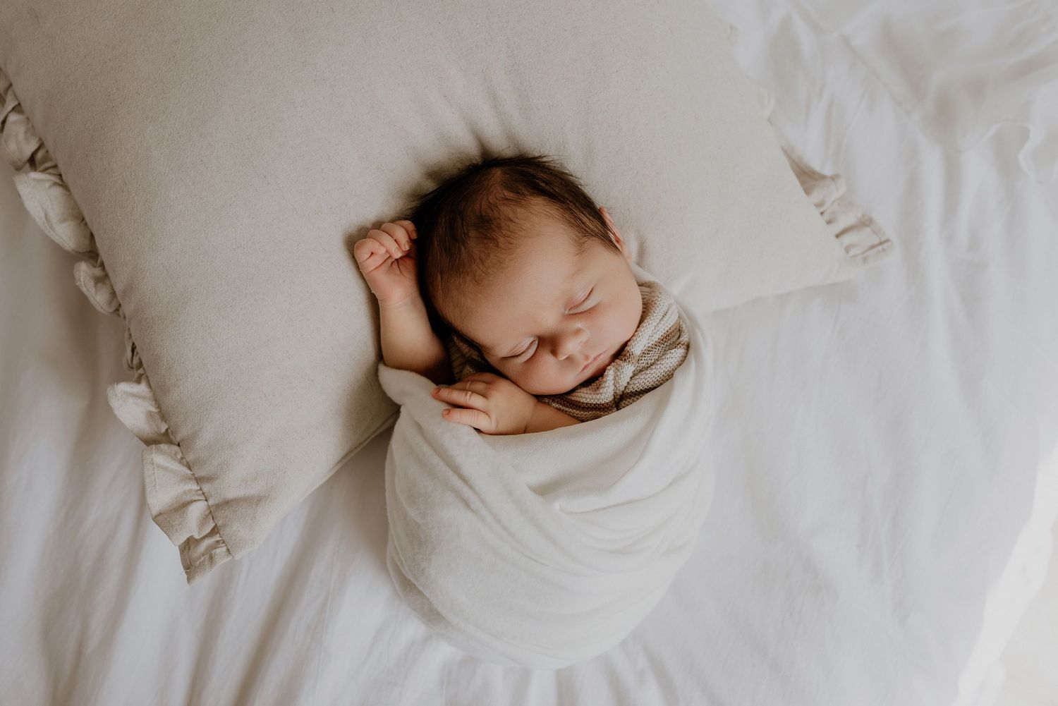 Heart and Gable newborn photography of baby wrapped in soft blanket, highlighting delicate details and innocence.