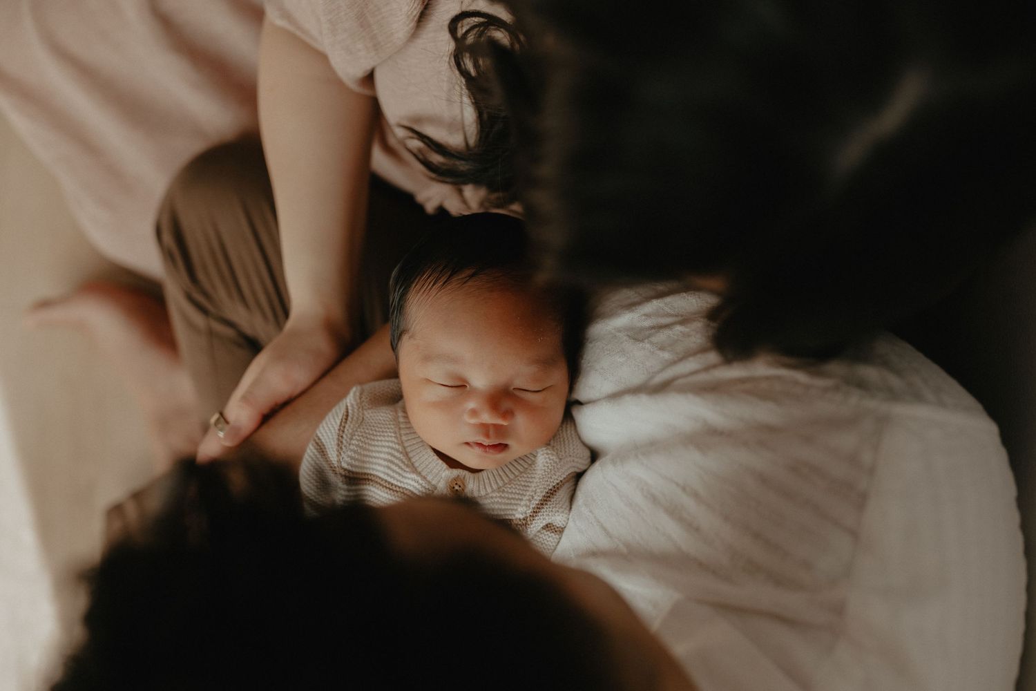 Adorable sleeping baby in cozy Edmonton studio setup, perfect example of newborn photography with soft lighting.