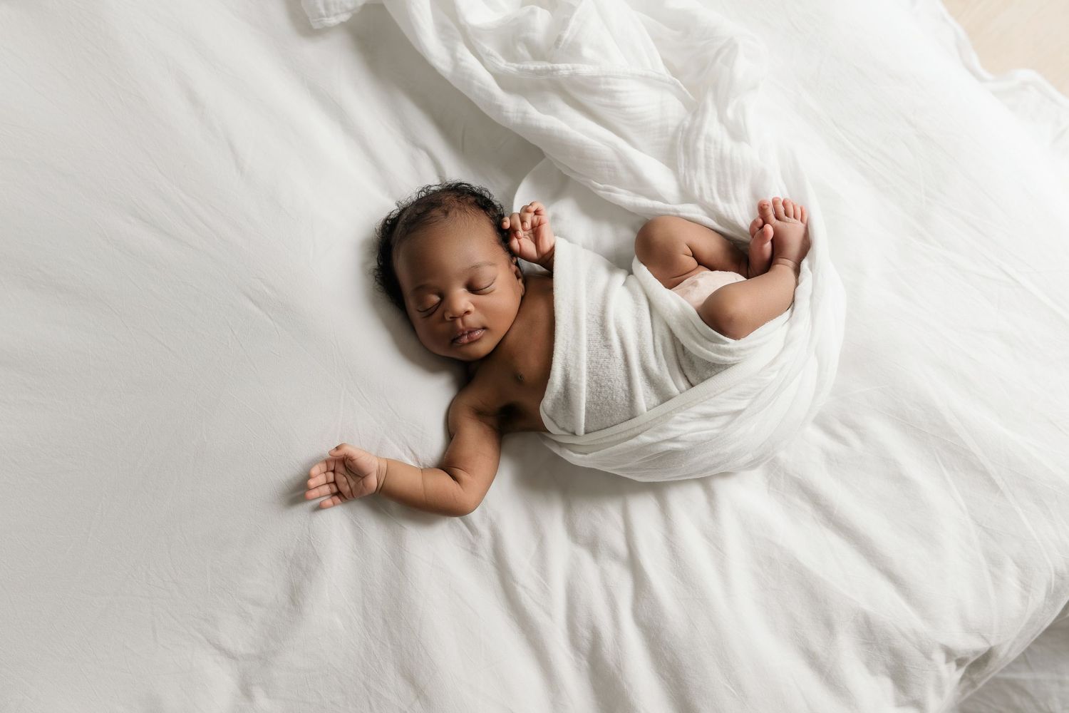 Heart and Gable newborn photography of baby wrapped in soft blanket, highlighting delicate details and innocence.