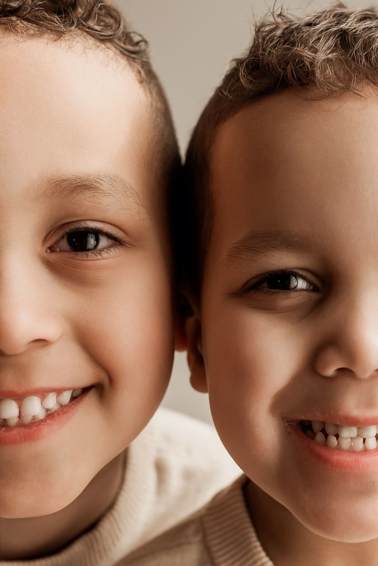 Smiling siblings in studio photography session in Edmonton, Alberta, capturing peaceful early life moments.