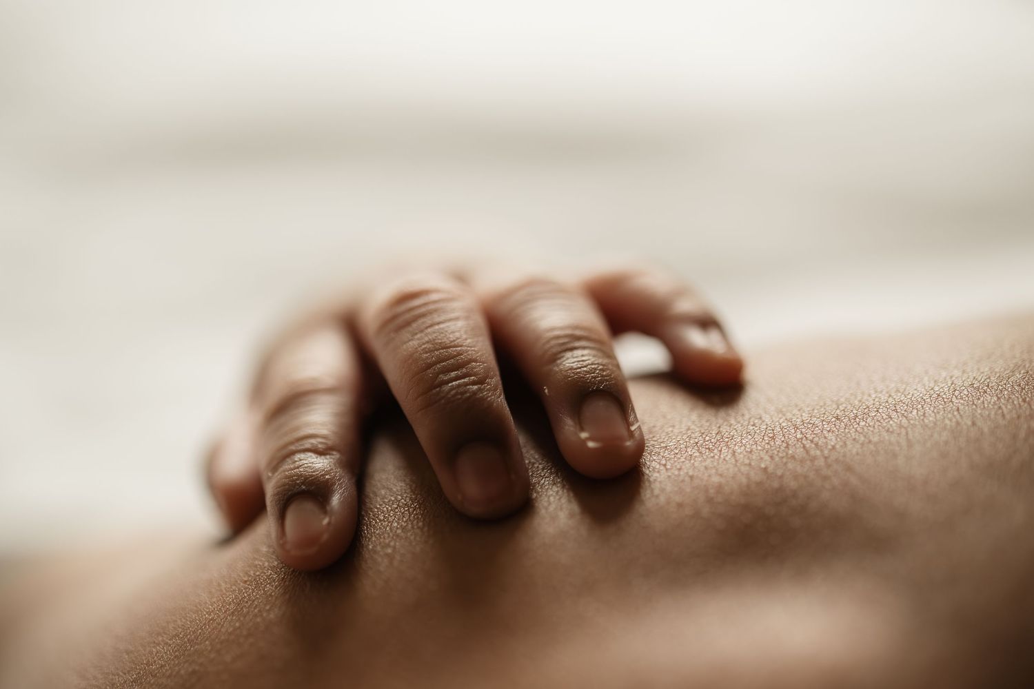 Close-up of newborn hands and feet in Edmonton studio, showcasing professional newborn photography style.