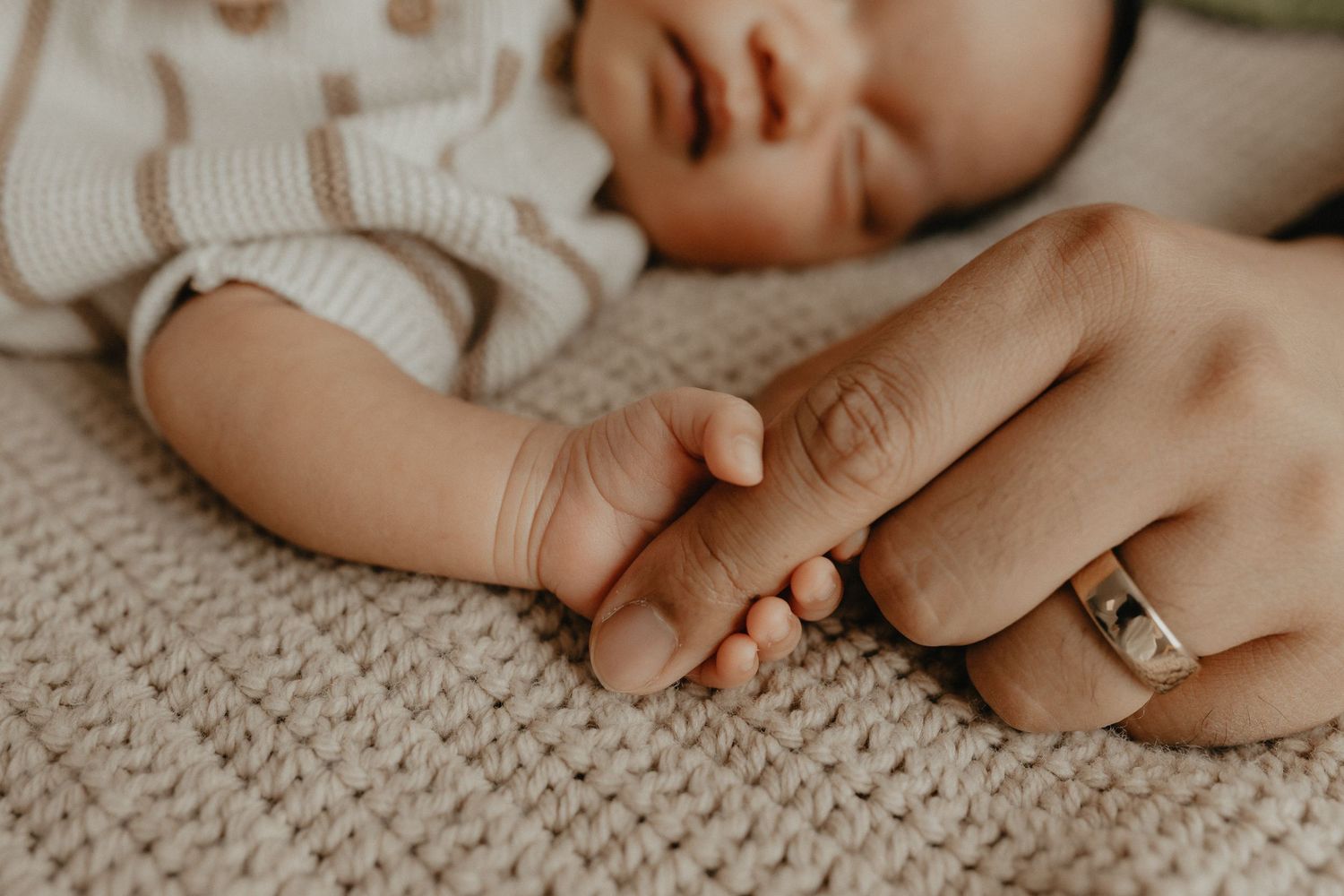 Close-up of newborn hands and feet in Edmonton studio, showcasing professional newborn photography style.