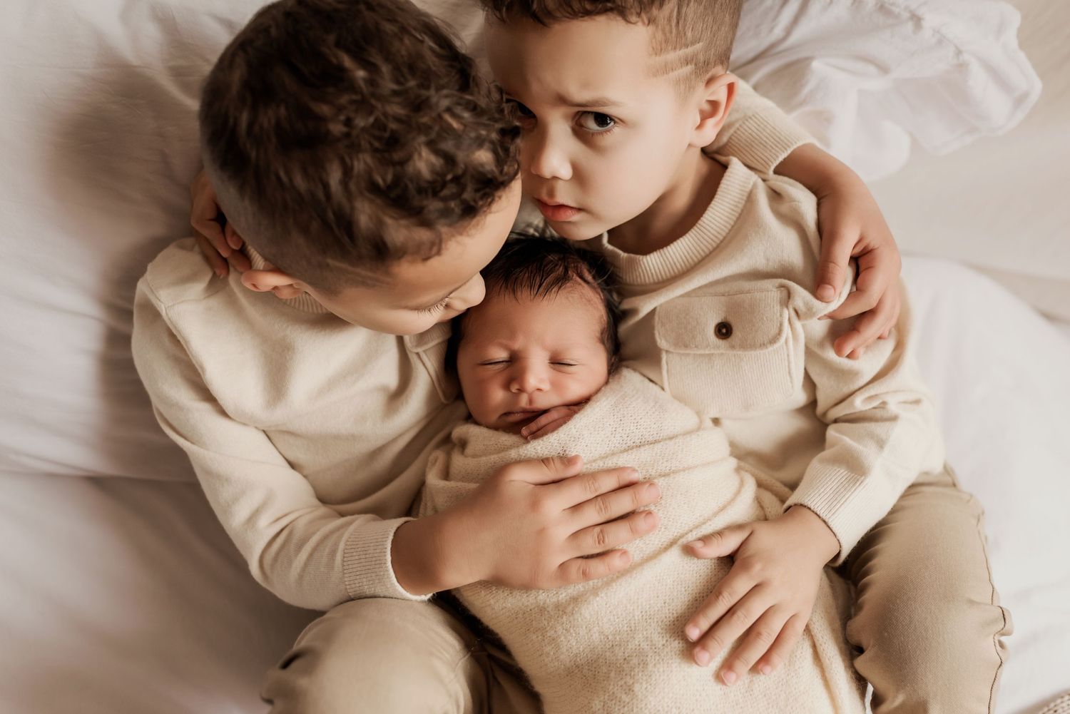 Smiling siblings in studio photography session in Edmonton, Alberta, capturing peaceful early life moments.