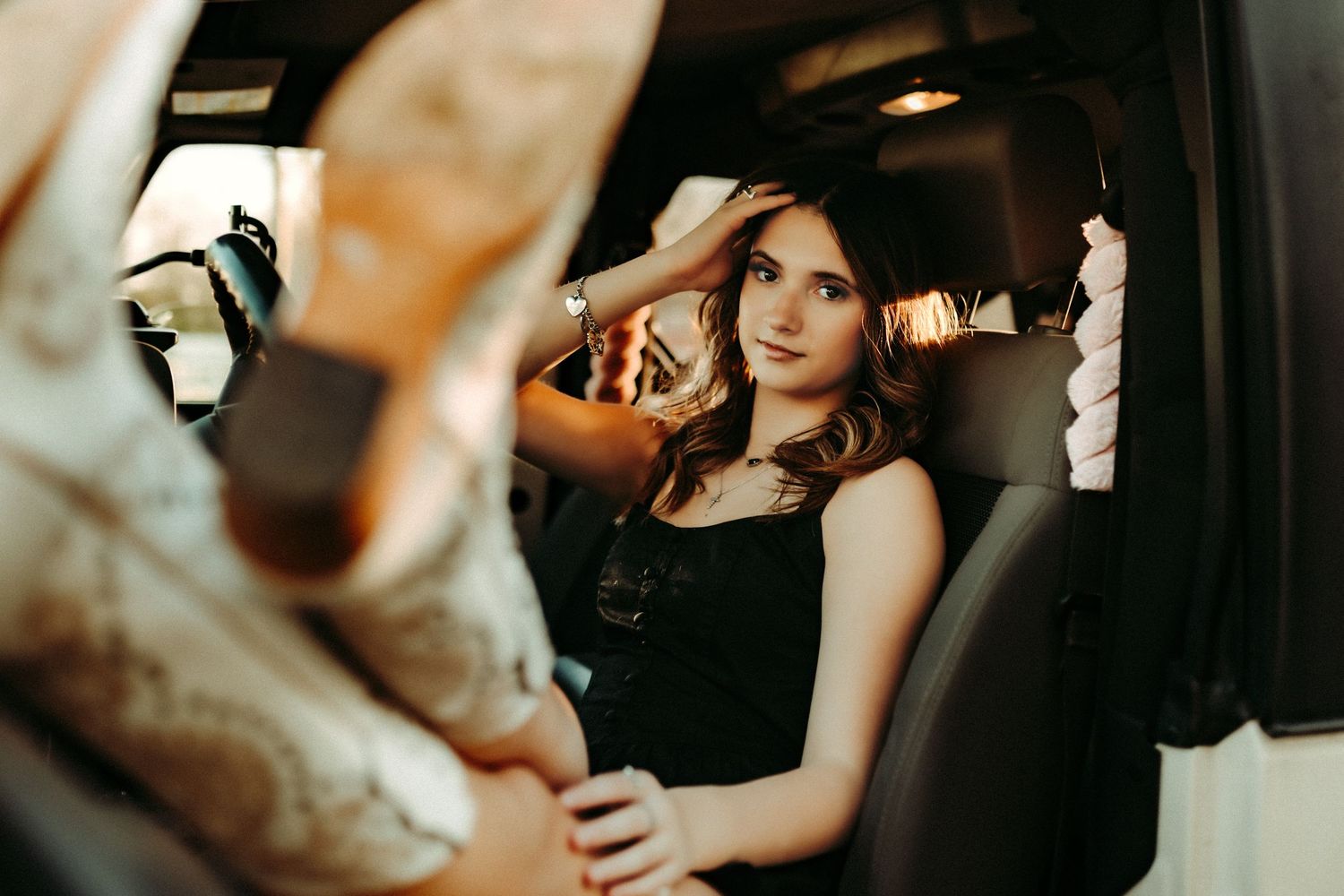 A woman in stunning black wedding dress poses elegantly in moody, dramatic lighting for bridal portraits.