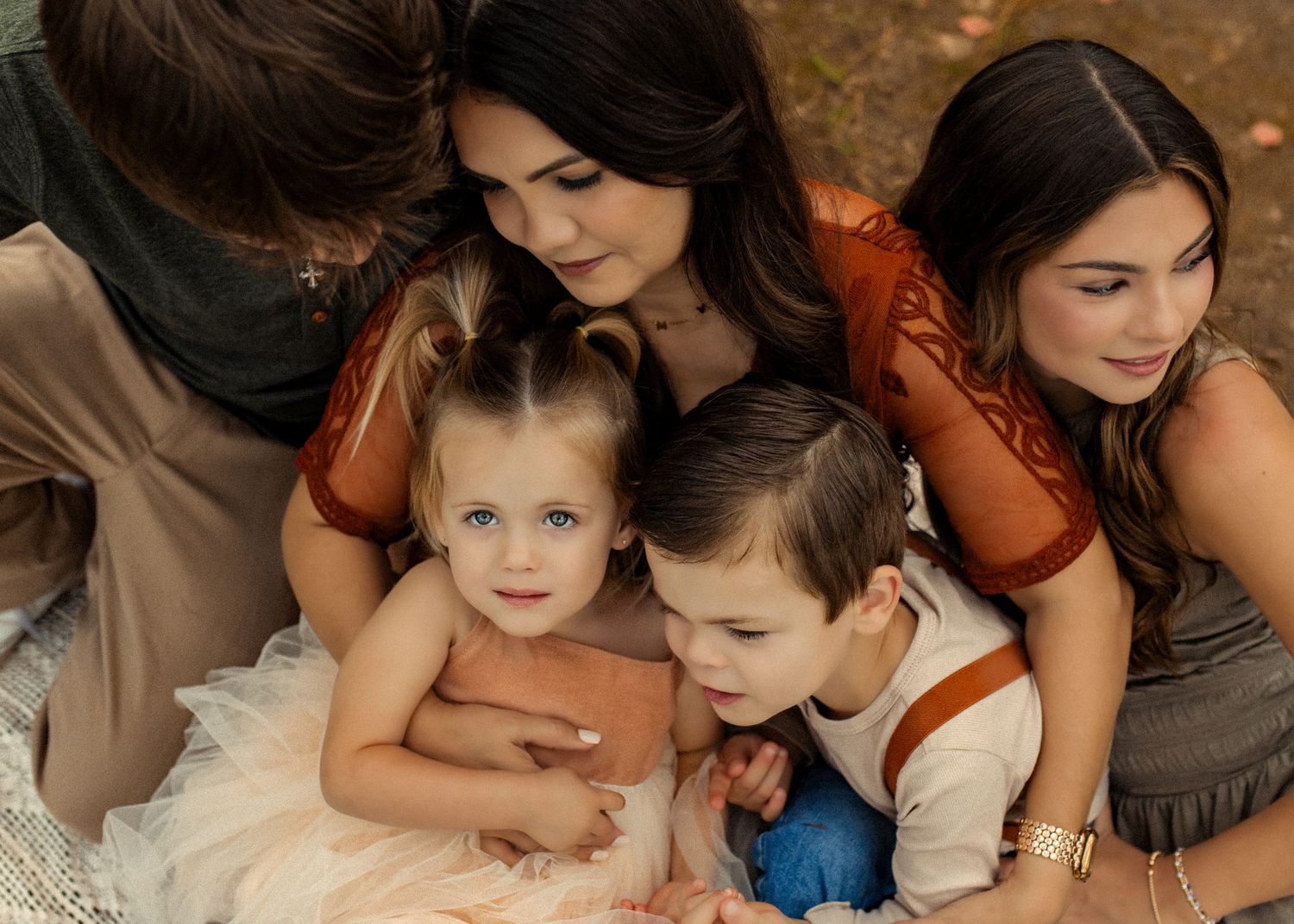 A series of warm-toned family photos showing tender moments between parent and child in matching outfits.