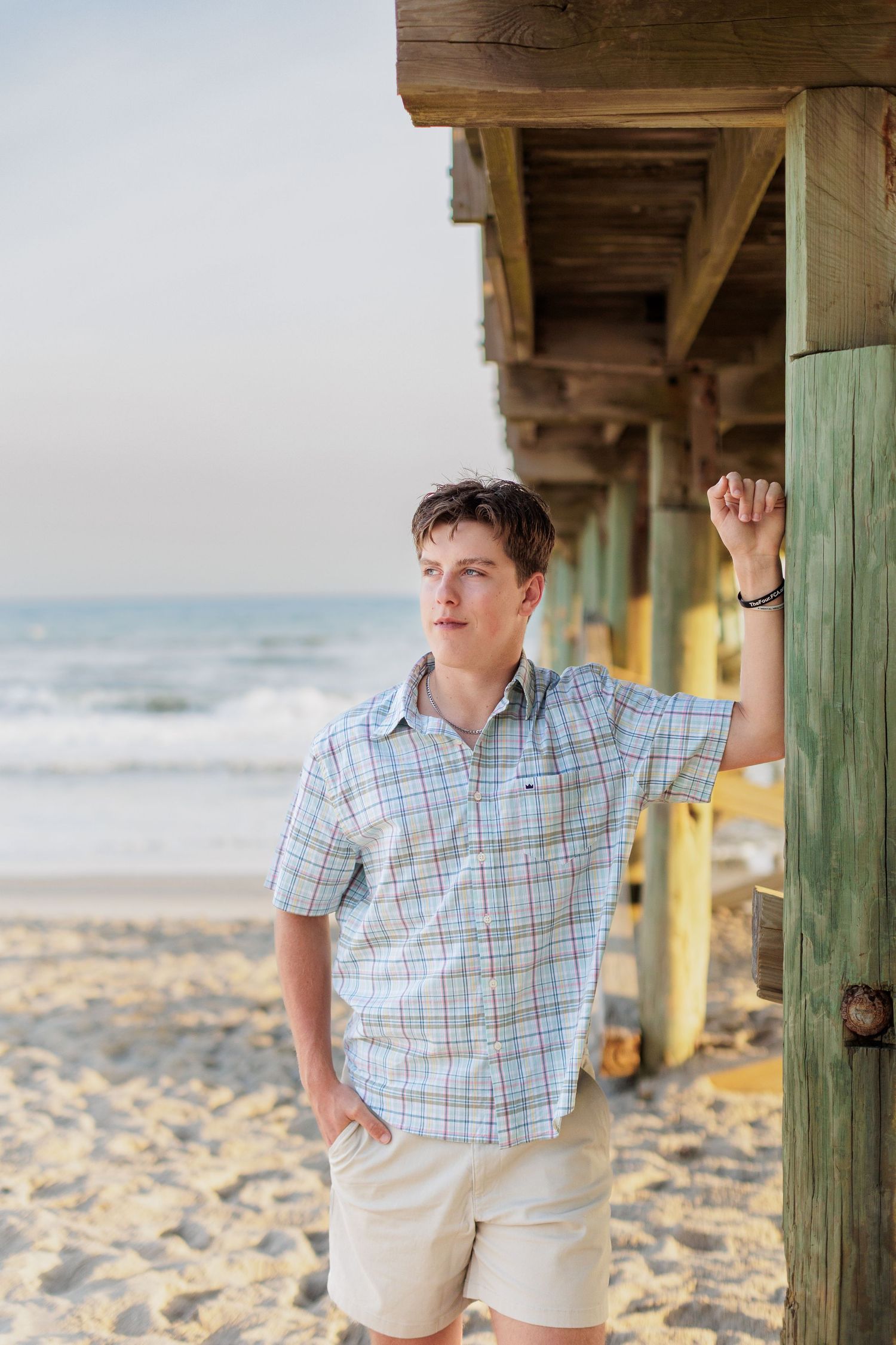 Boy Senior Photography Session in Atlantic Beach, NC near pier at sunset.