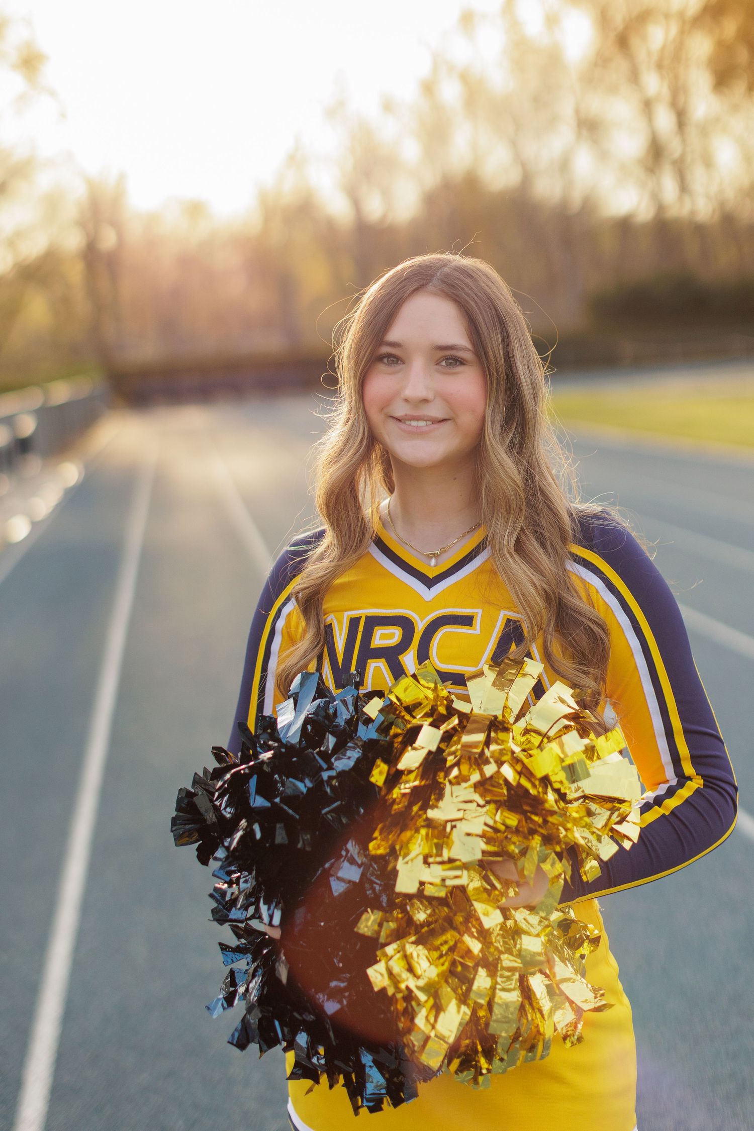 Raleigh Senior Session in cheerleading uniform at field.