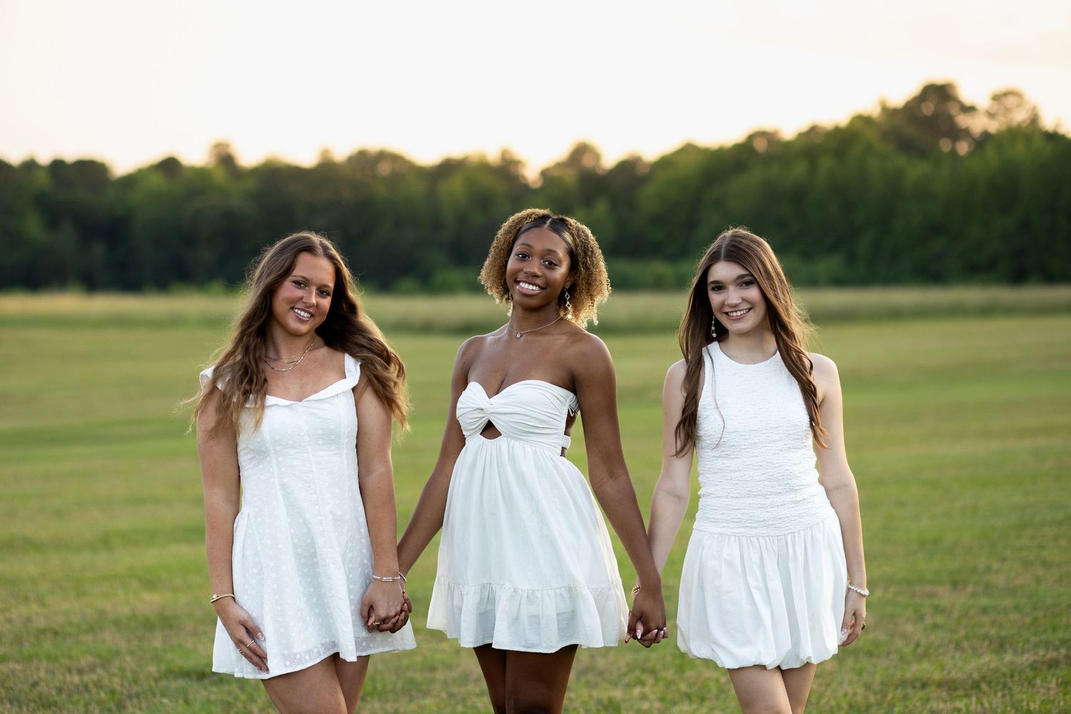 Besties celebrating graduation in a cap and gown mini session at sunset in Raleigh, NC