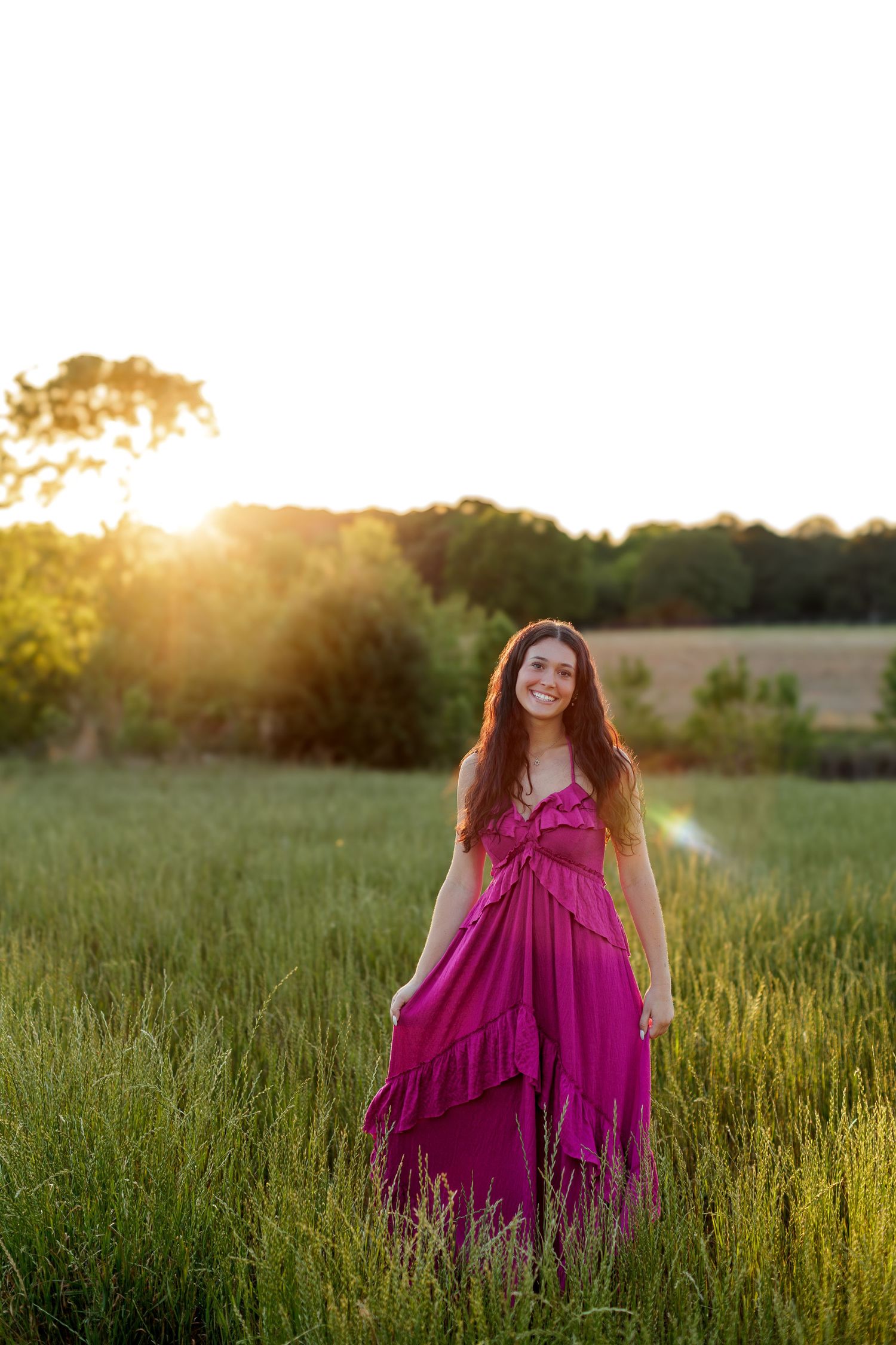 Wake Forest Senior Session at Juniper Creek Farm in wildflower field during golden hour in Raleigh, NC.