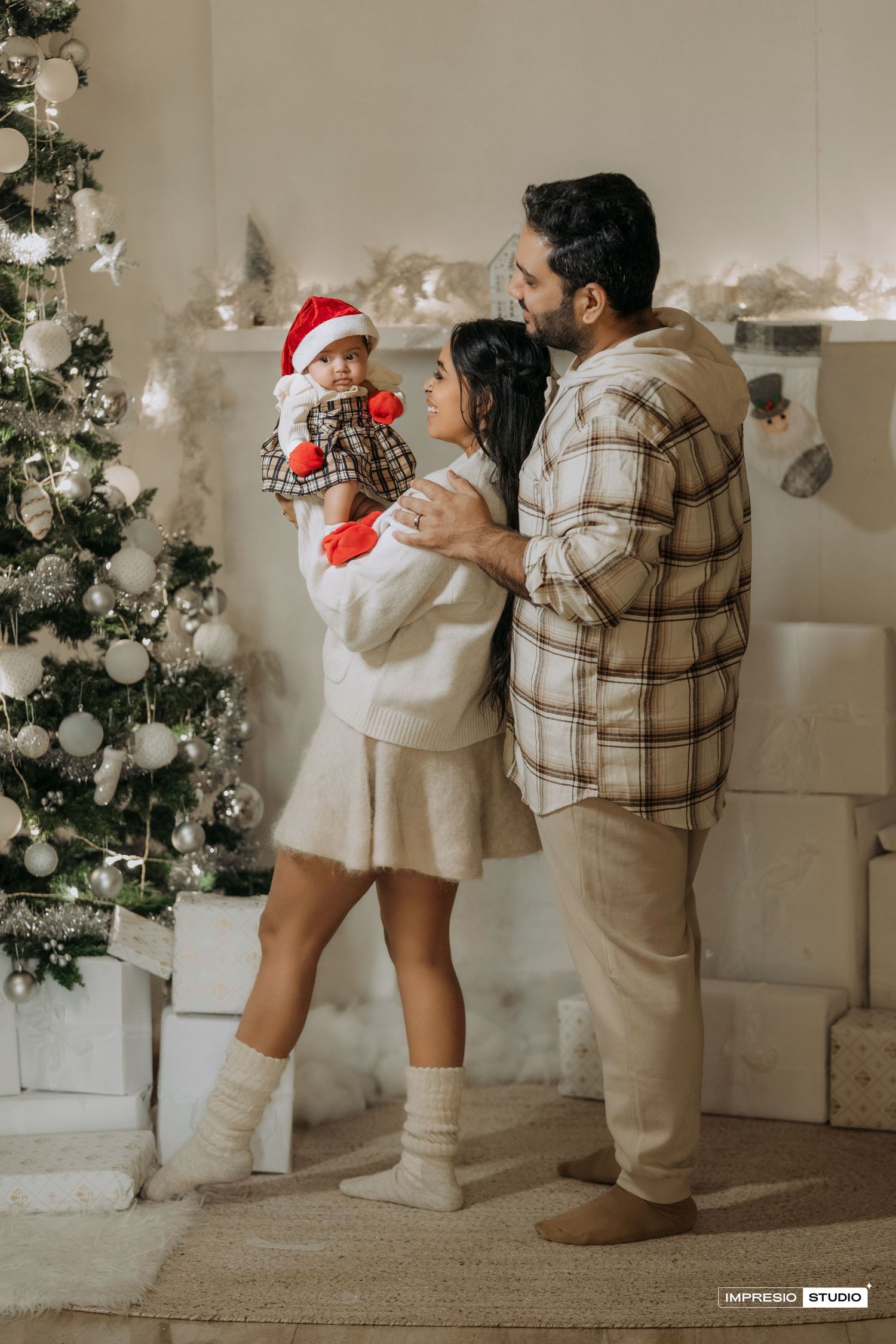 A series of photos showing a toddler and parent in cozy winter outfits looking at Christmas decorations together.
