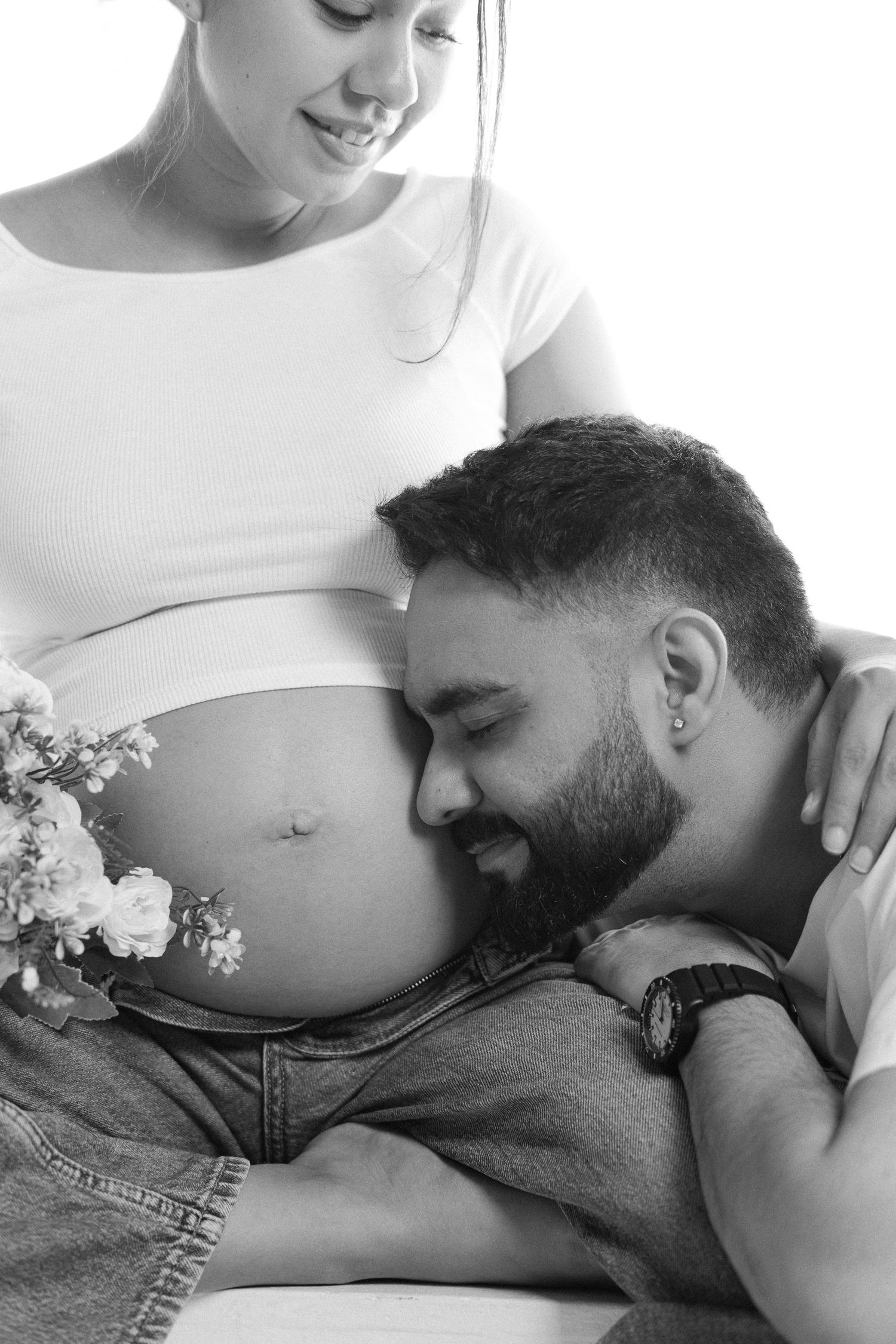 A series of black and white photos showing a tender moment between an expecting couple during a maternity photoshoot.