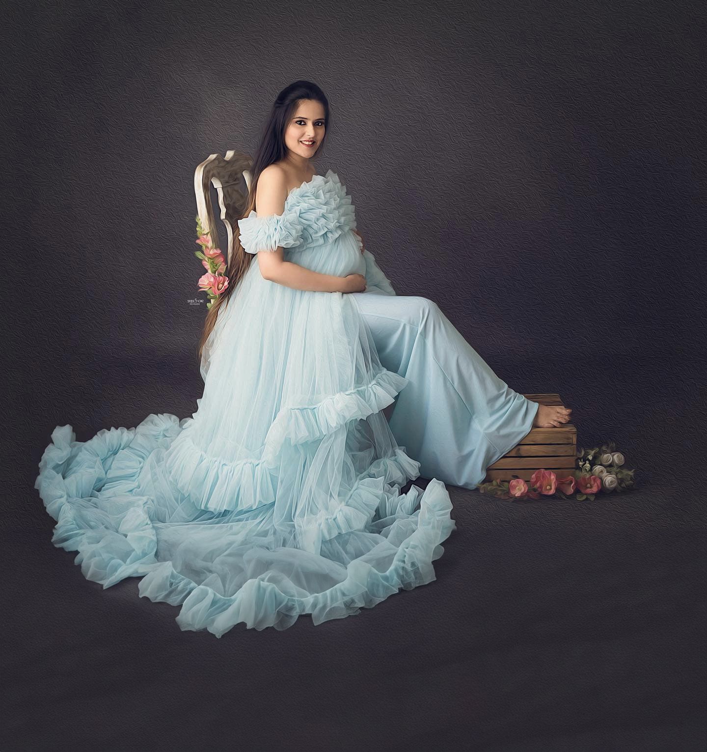 Dreamy maternity session with floral elements and a flowing light blue gown.
