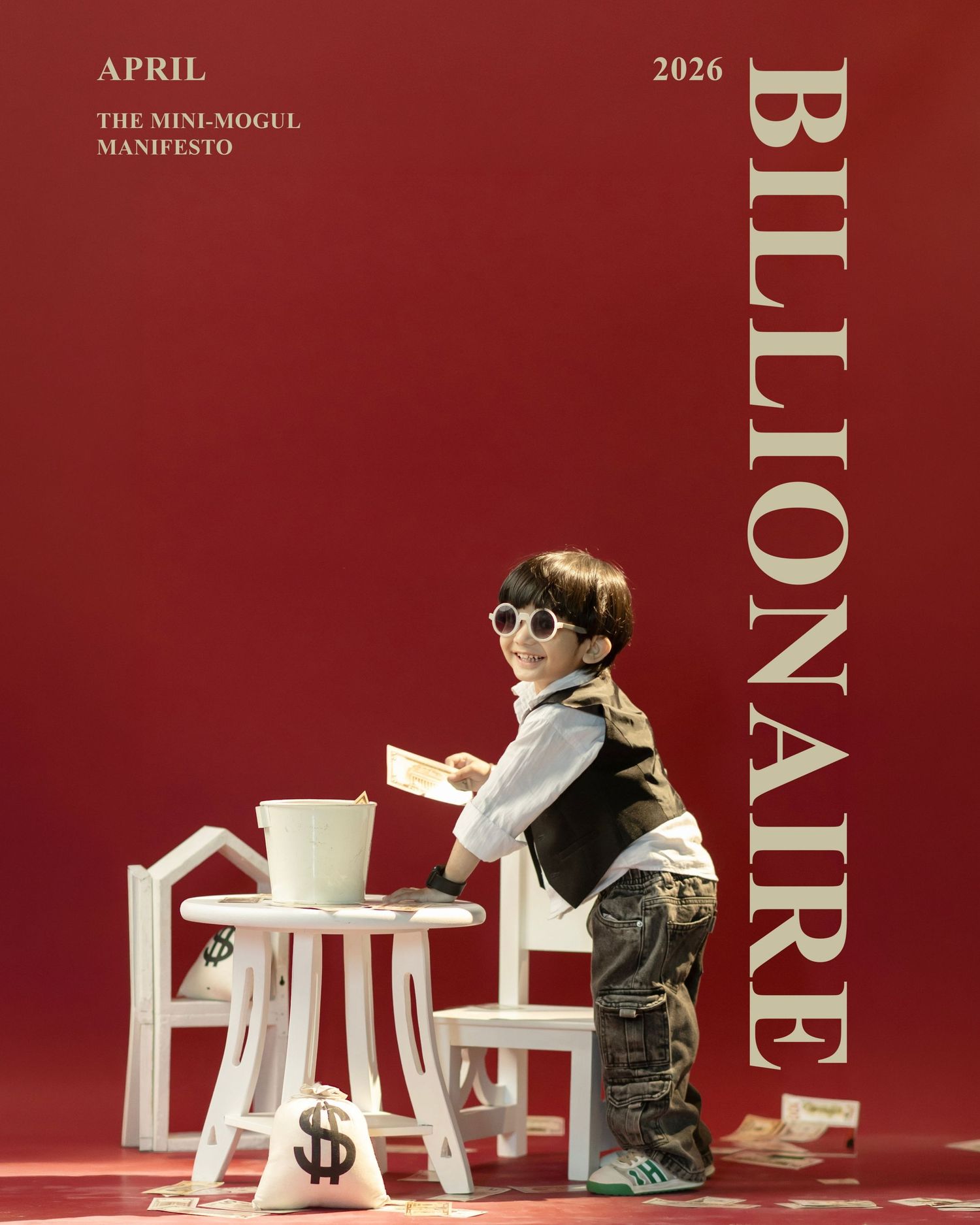 Child dressed as mini mogul poses with money bags and white furniture on red background for Billionaire magazine cover.