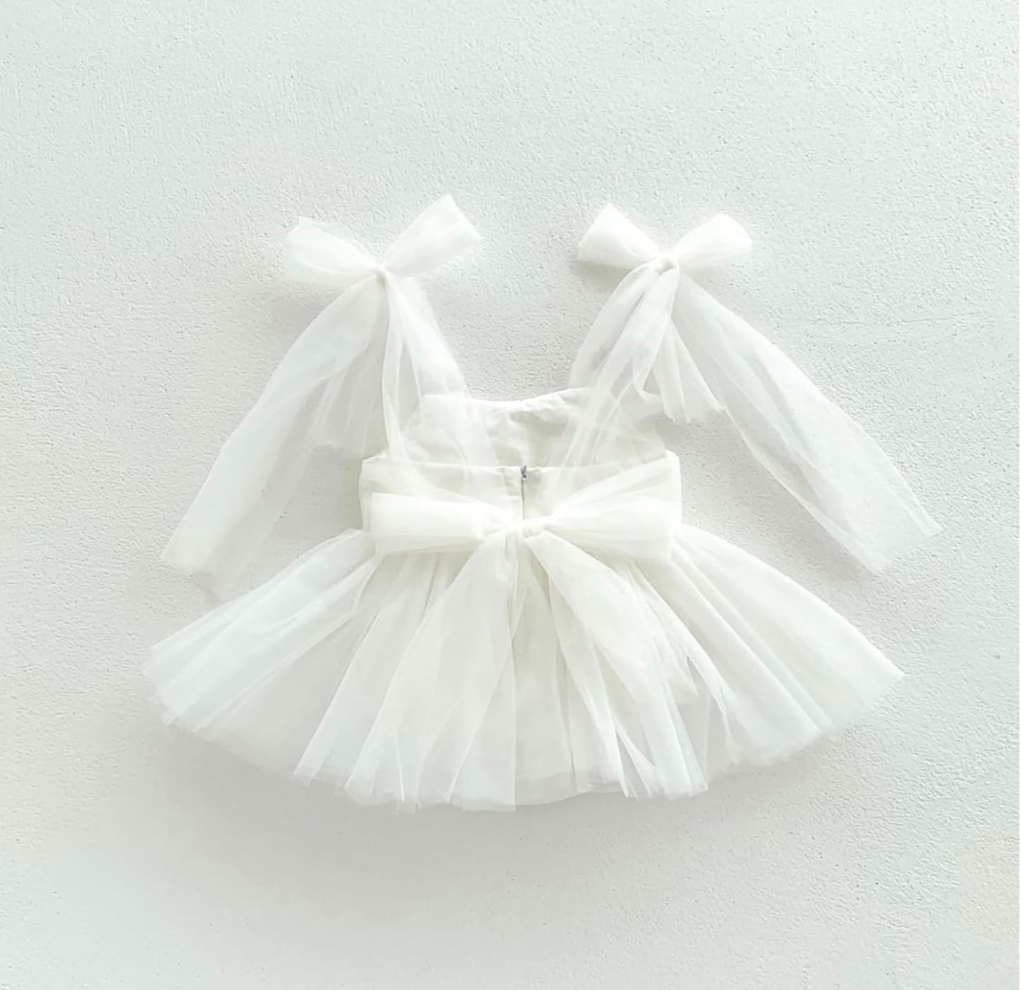 Collection of delicate white tulle tutu skirts arranged in a row on light background showing ballet fashion.