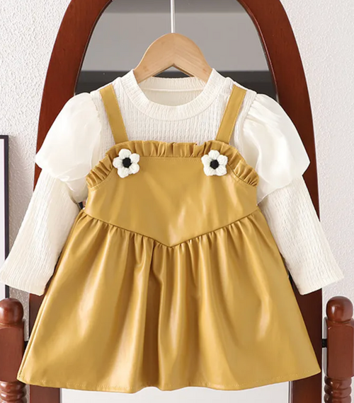 Yellow ruffle dress detail showcasing gathered fabric and white trim accents.