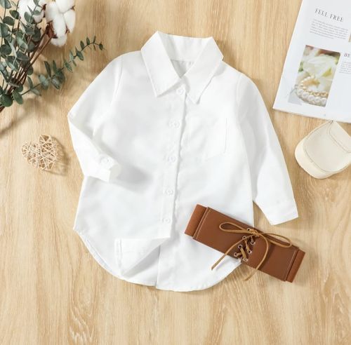 Classic white button-down shirt with brown corset belt on wooden surface.