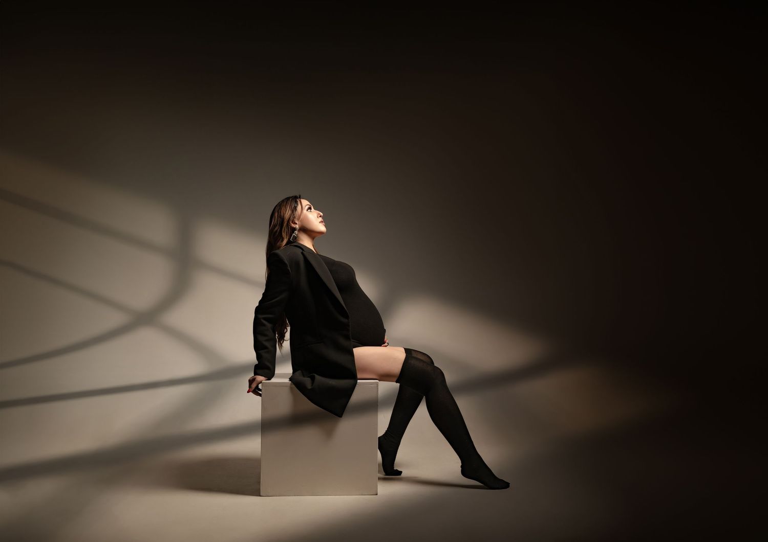 Artistic shadow play on floor with dramatic spot lighting in studio setting.