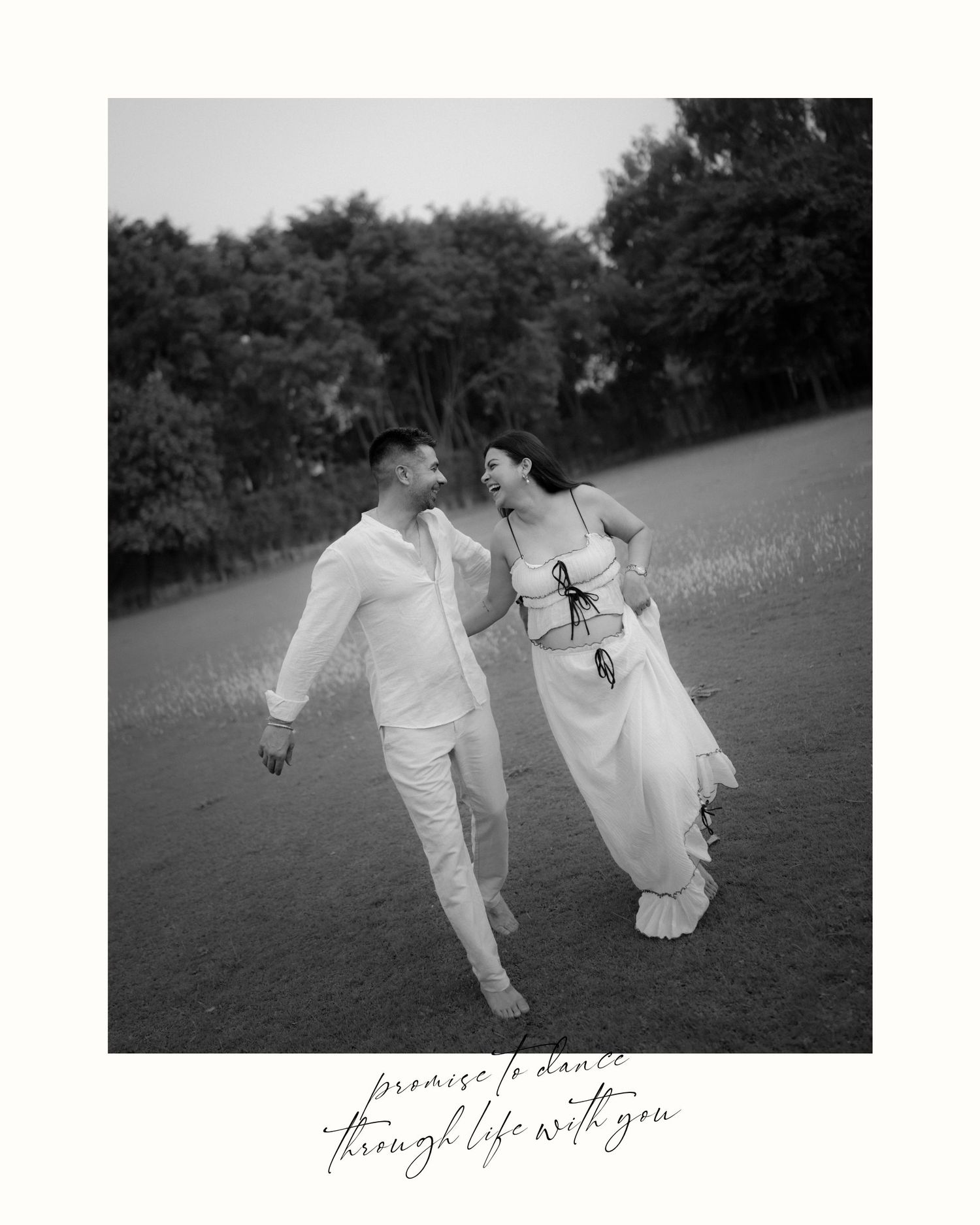 Black and white photo of a couple walking hand in hand in a field, wearing white outfits, with cursive text overlay.