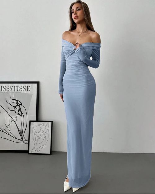 Elegant powder blue off-shoulder maxi dress with ruched details and long sleeves paired with white pointed heels.