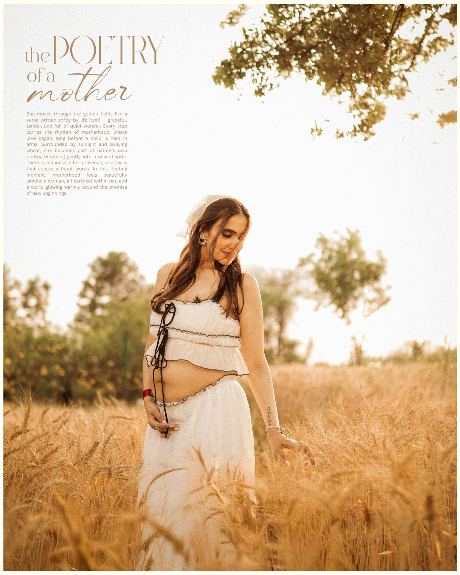 Pregnant woman in white crop top and skirt standing in golden wheat field, maternity photography shoot.