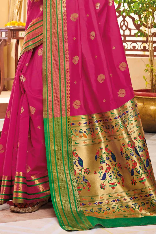 Vibrant pink silk saree with traditional paithani border featuring colorful peacock motifs.
