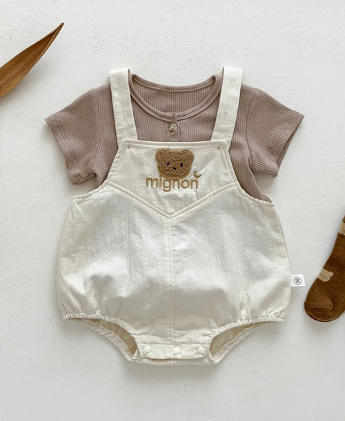 White cotton romper with brown t-shirt combination laid flat on display.